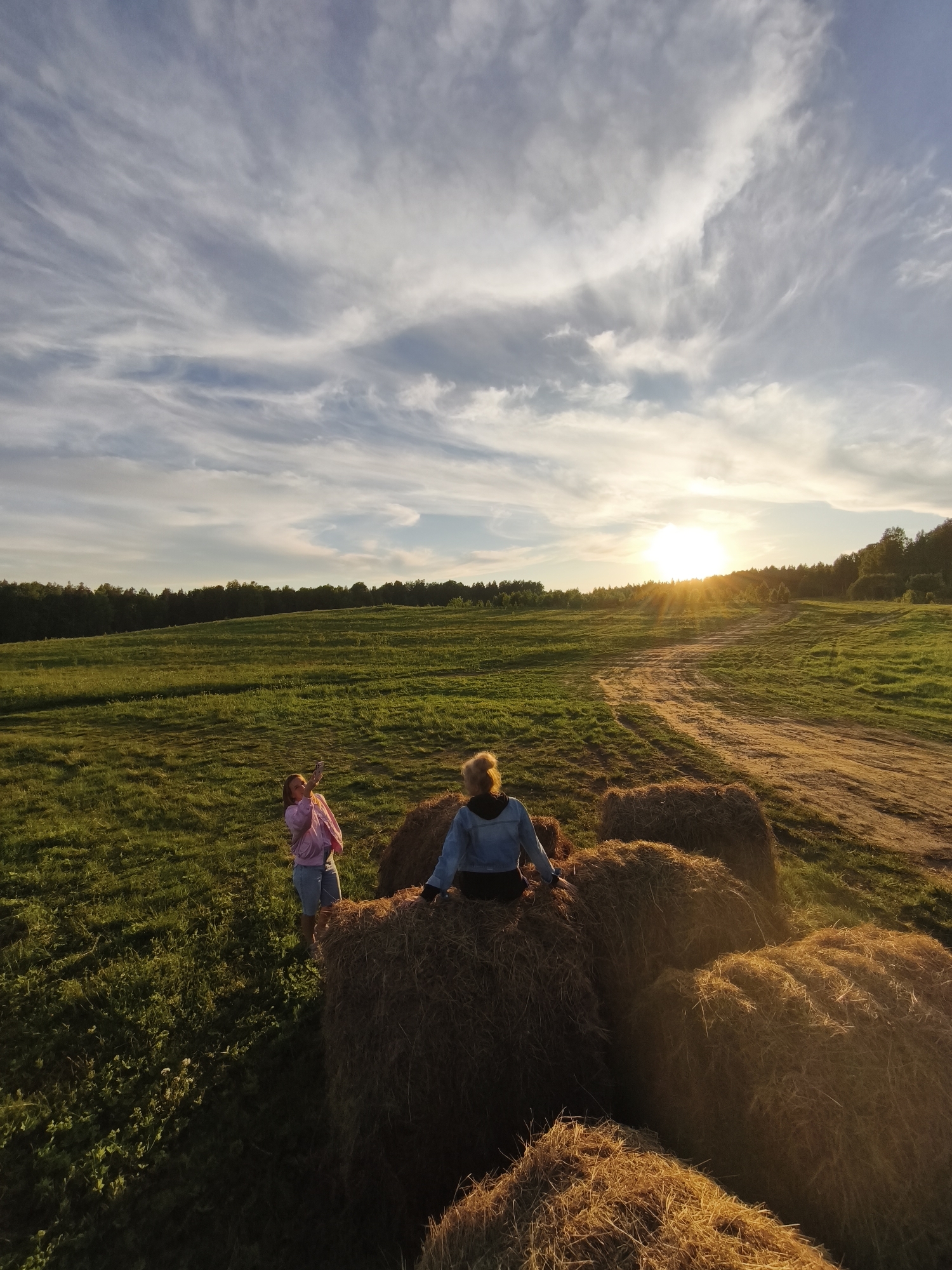 Women enjoy golden hour in Russian countryside hay fields