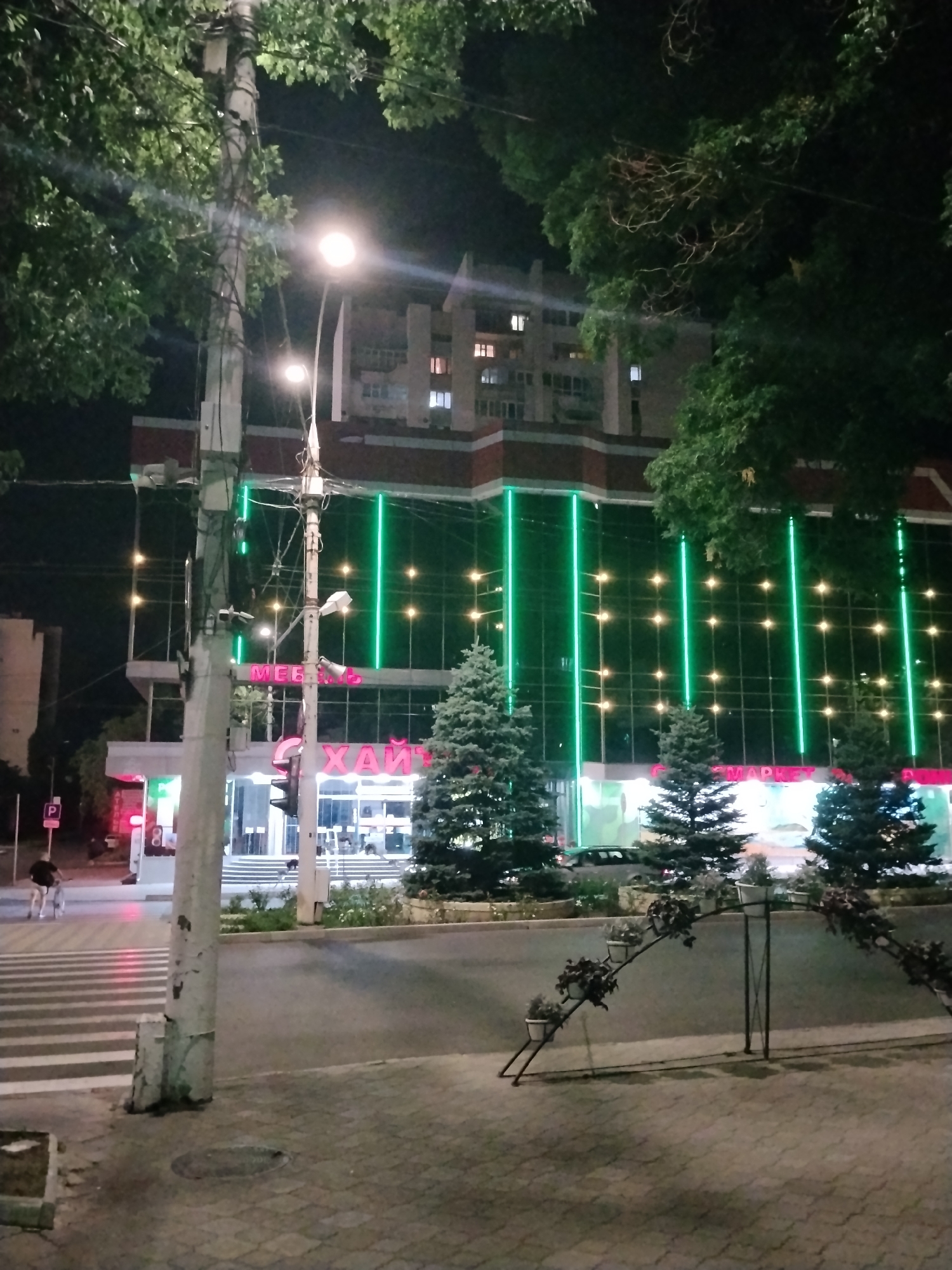 Illuminated buildings and fountain draw evening foot traffic