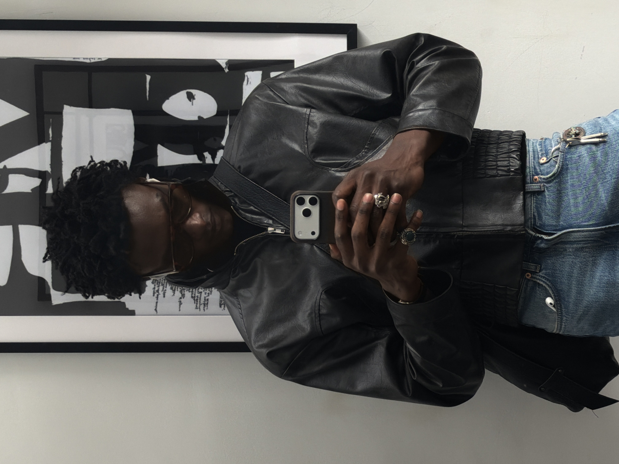 Man takes selfies indoors in London wearing leather jacket