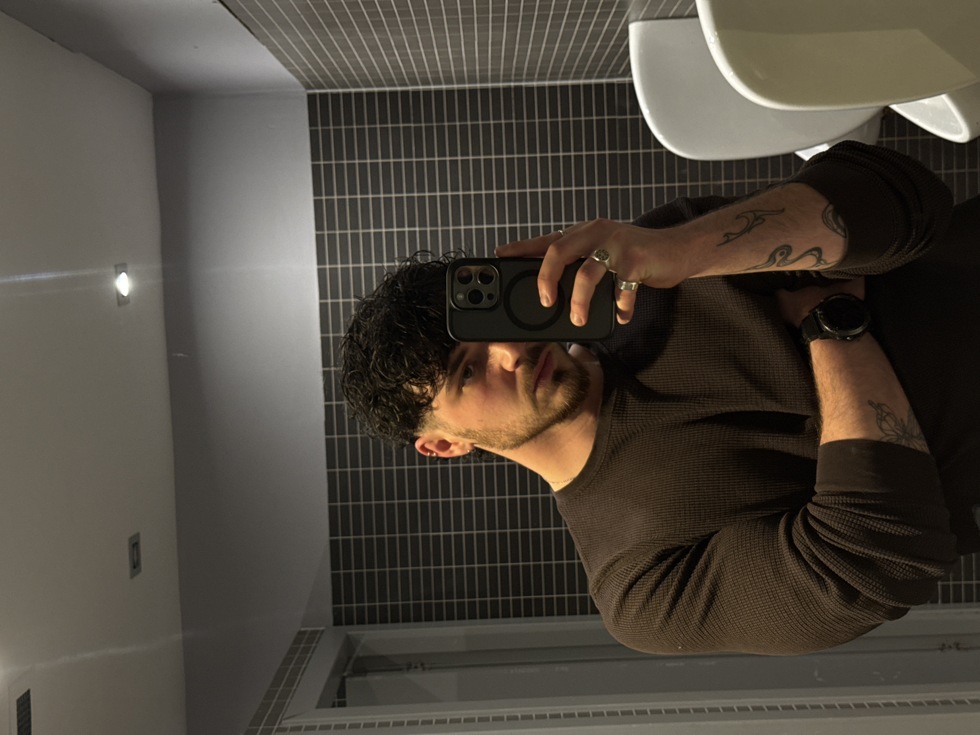Man Takes Mirror Selfie in Tiled Bathroom