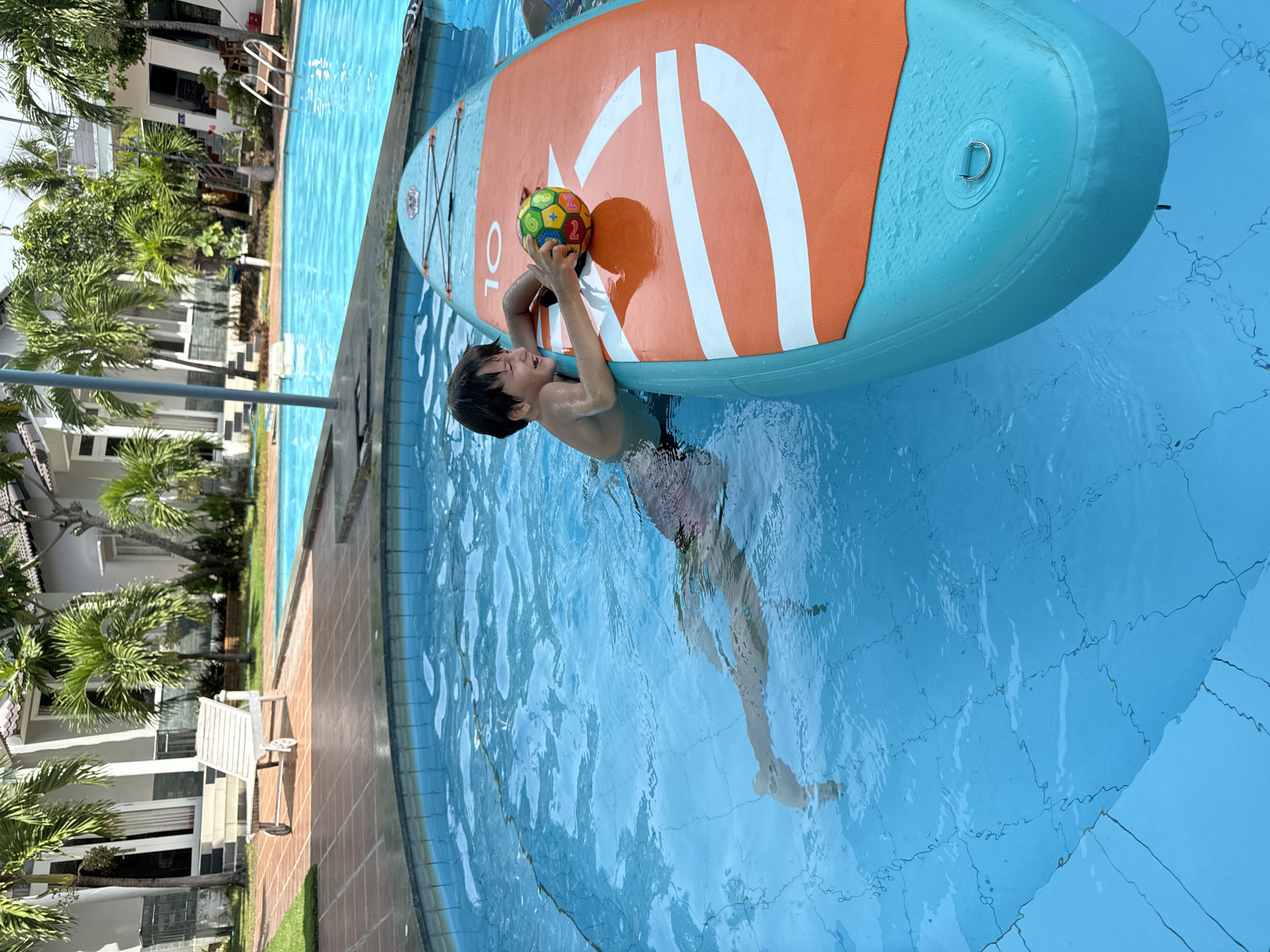 Pool day at a Mũi Né resort with paddleboard and poolside fruit