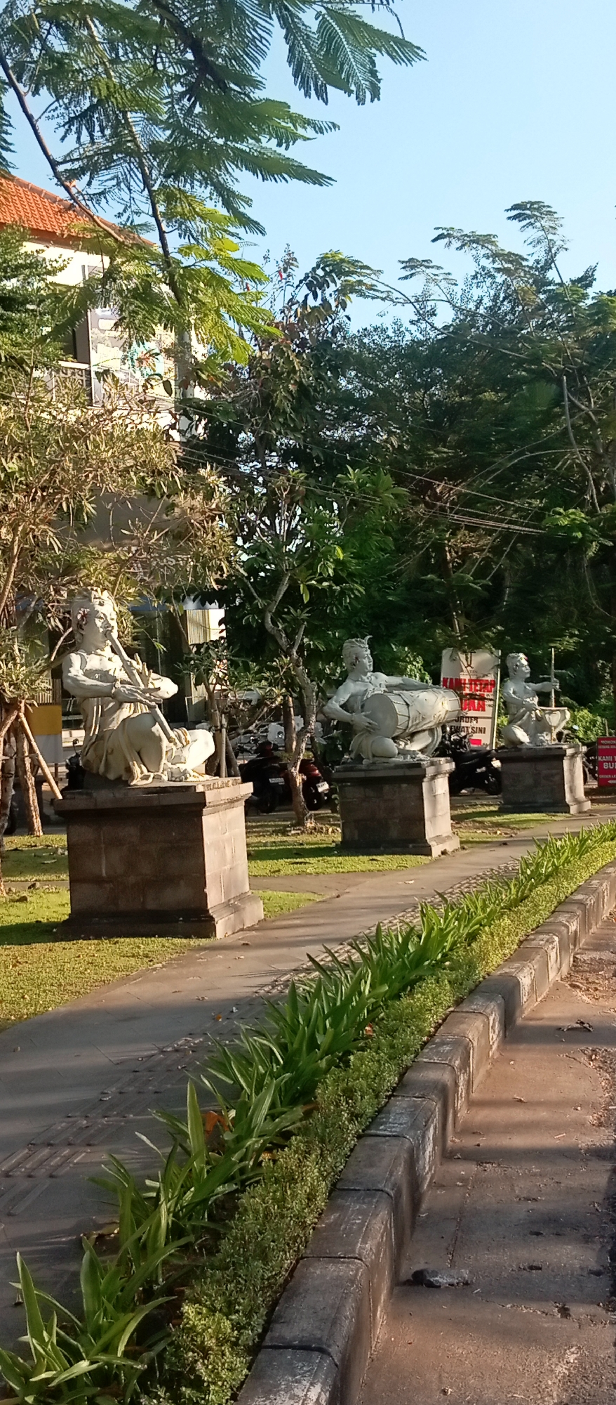 Stone musician sculptures line a walkway in Gianyar, Bali