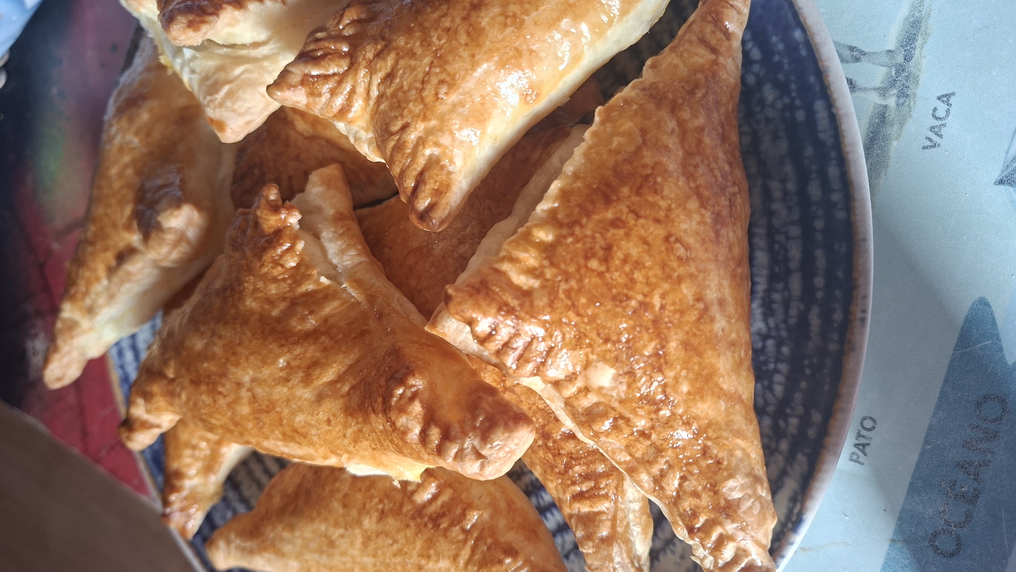 Golden triangular pastries served on patterned plate in Castro