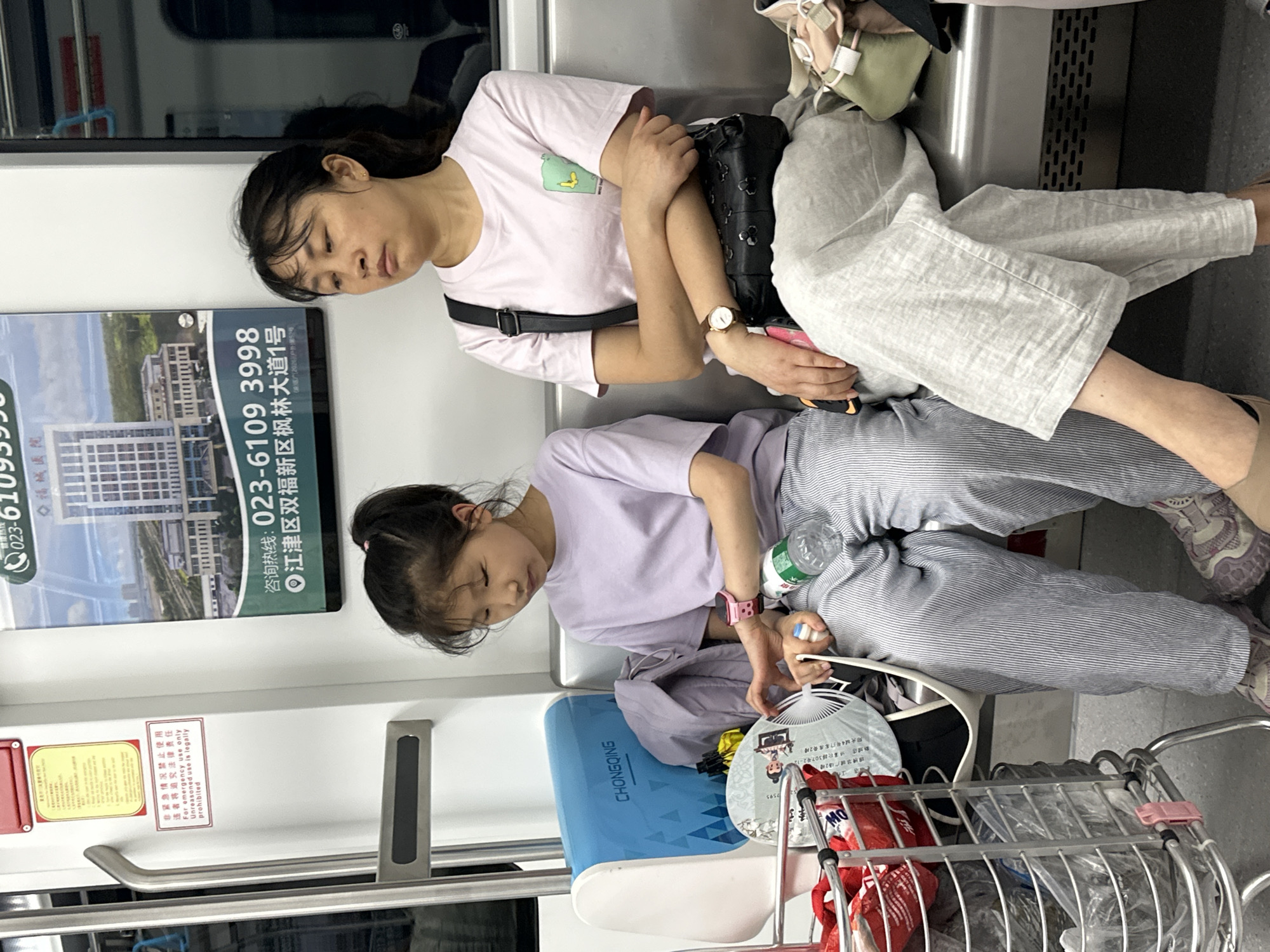 Woman and child sleep on transit in Jiulongpo District