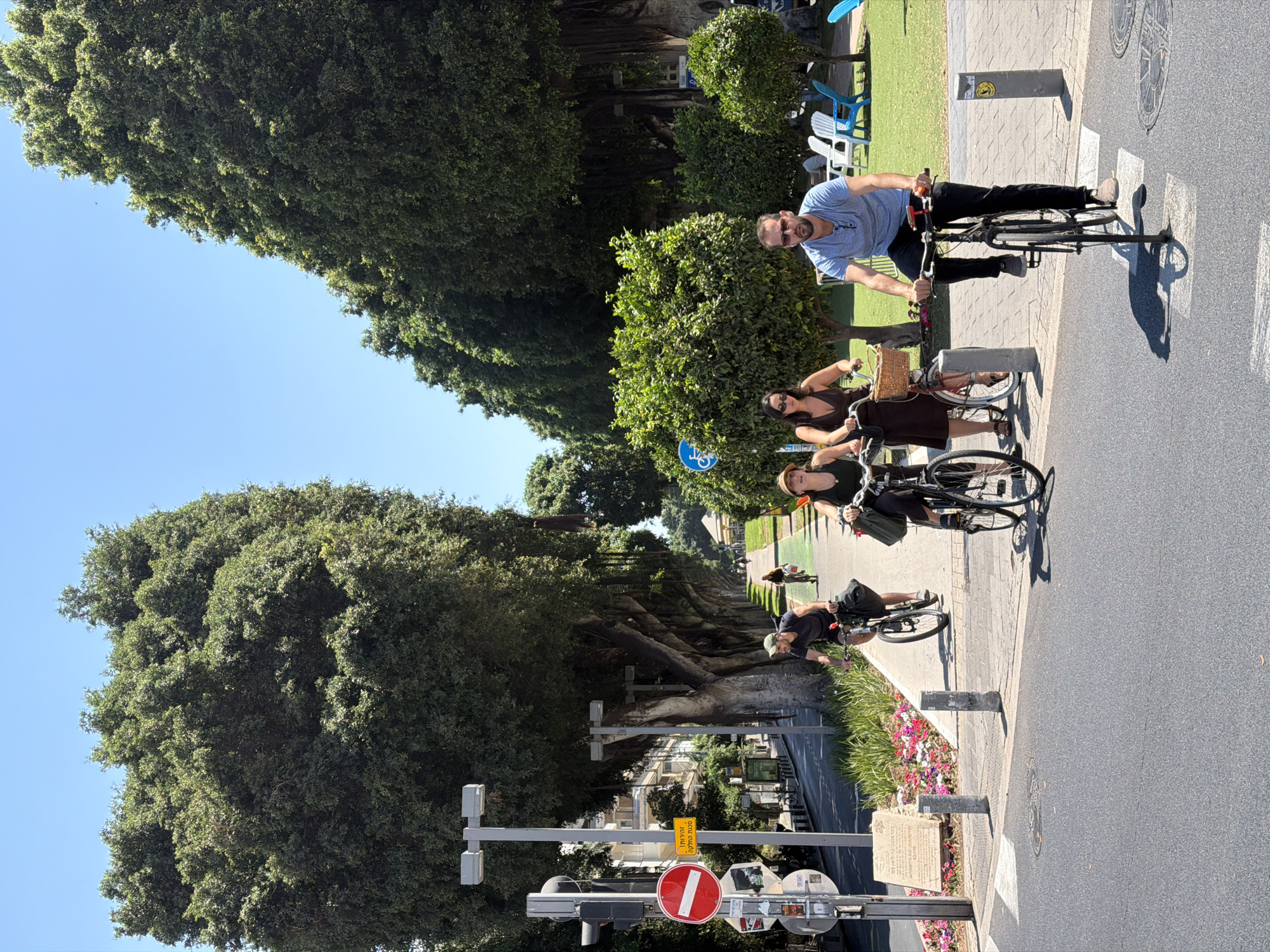 Cyclists rolling down Rothschild Boulevard's shaded bike path