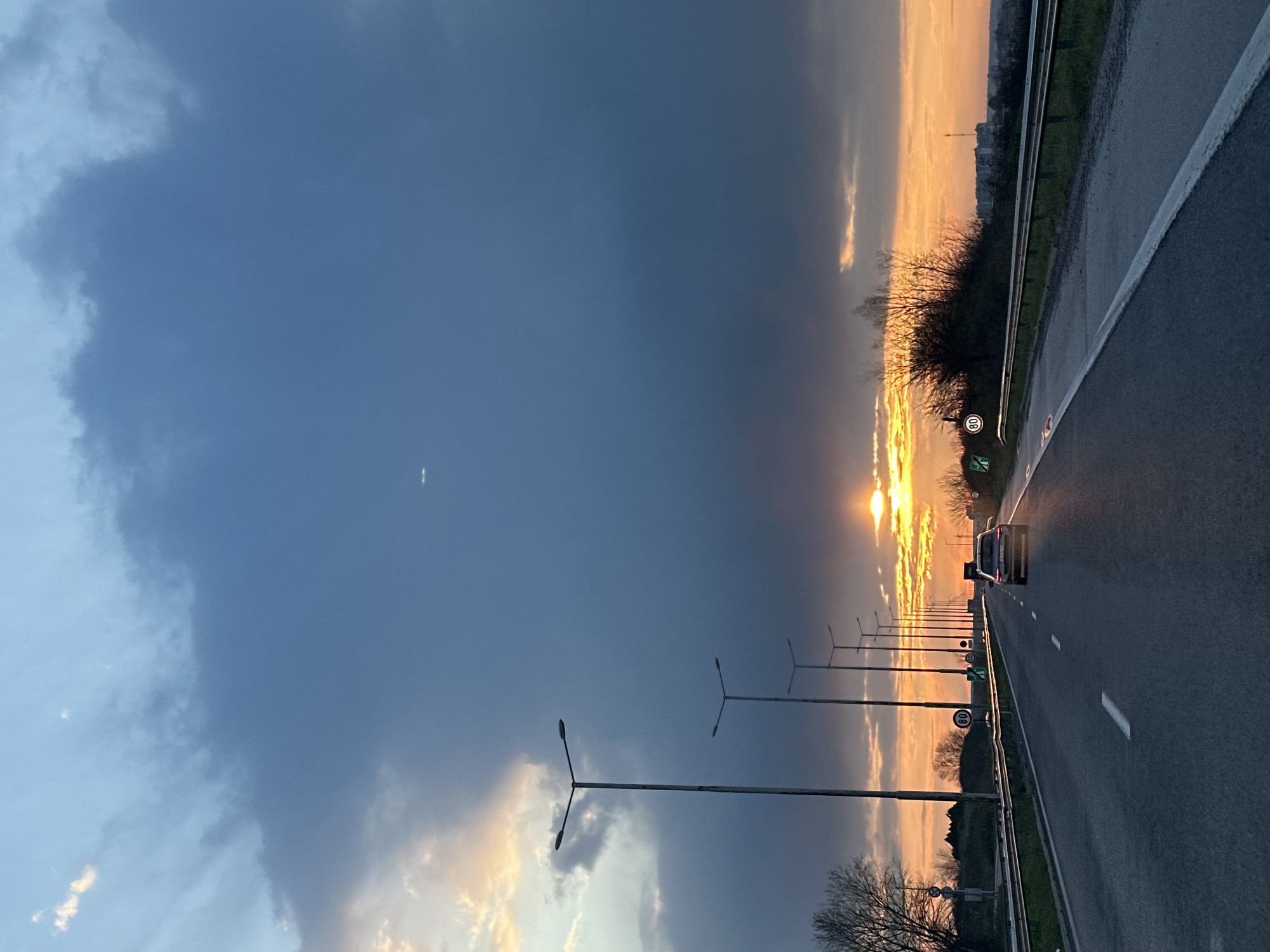 Car travels wet highway at sunset near Svilengrad, Bulgaria