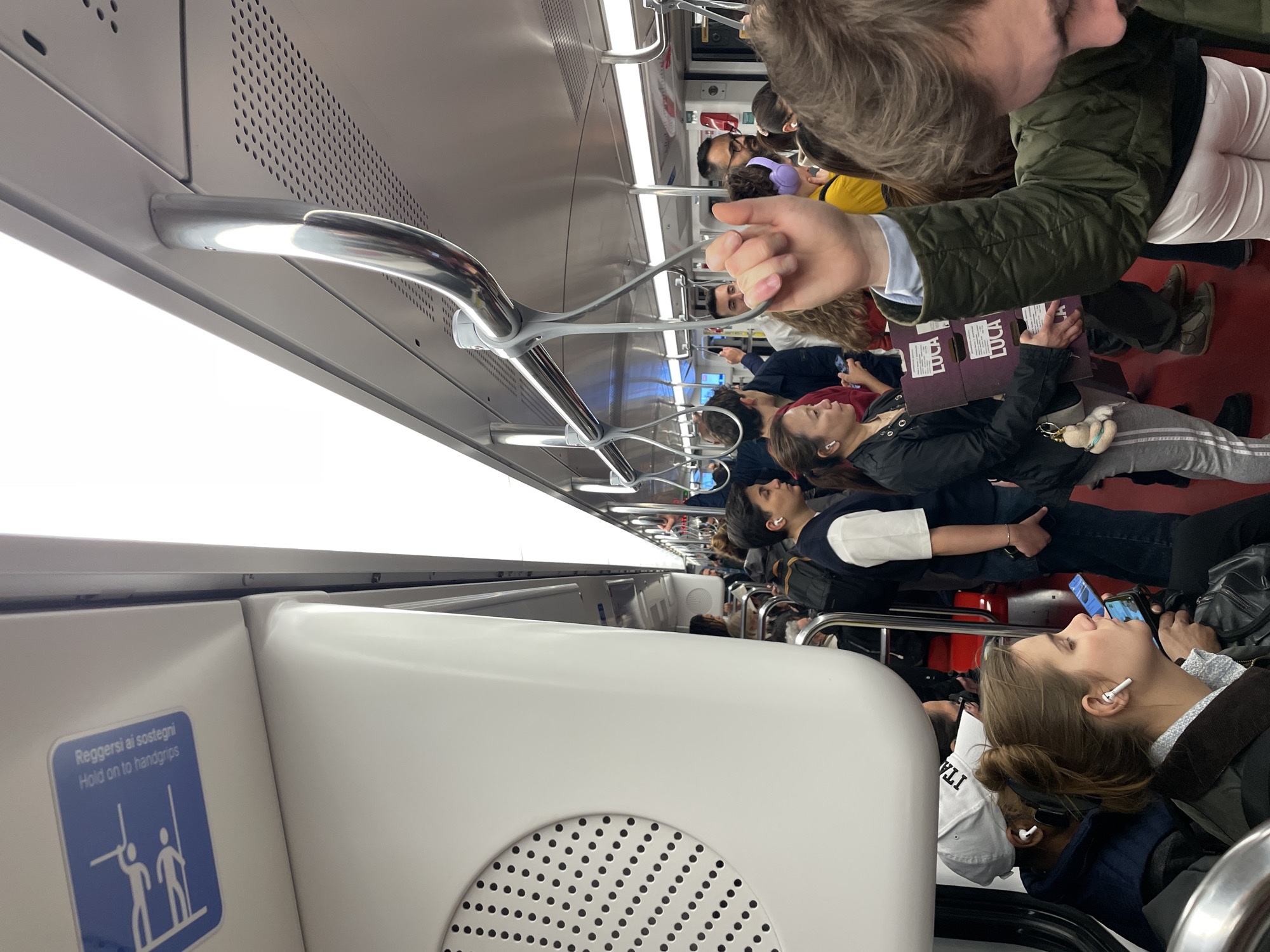 Rush hour commuters fill Milan subway car during evening transit