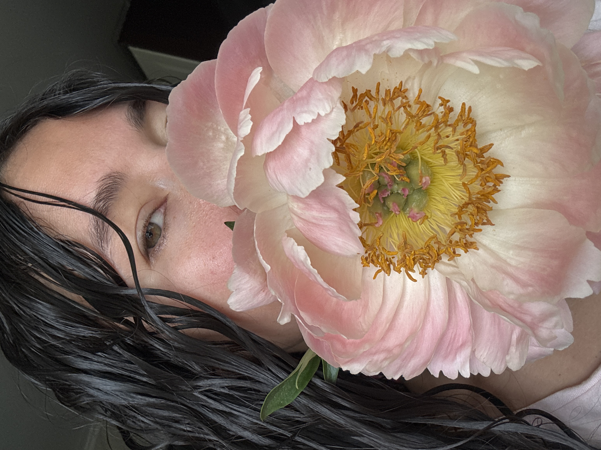 Person poses with peony flowers in Kazan kitchen