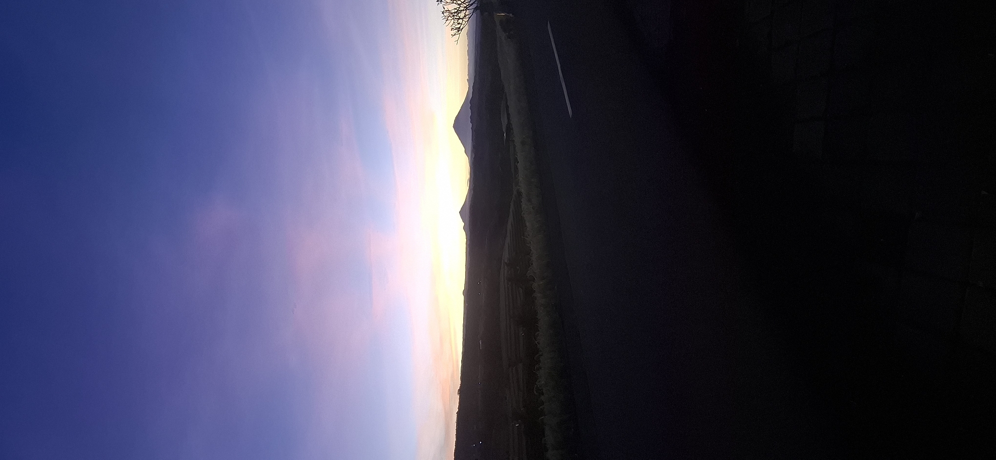 Evening sky gradient observed over terraced mountains in Penebel