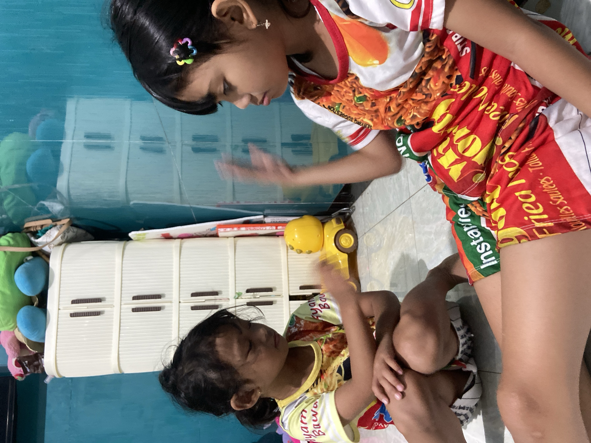 Kids playing games and eating at home in Gelam