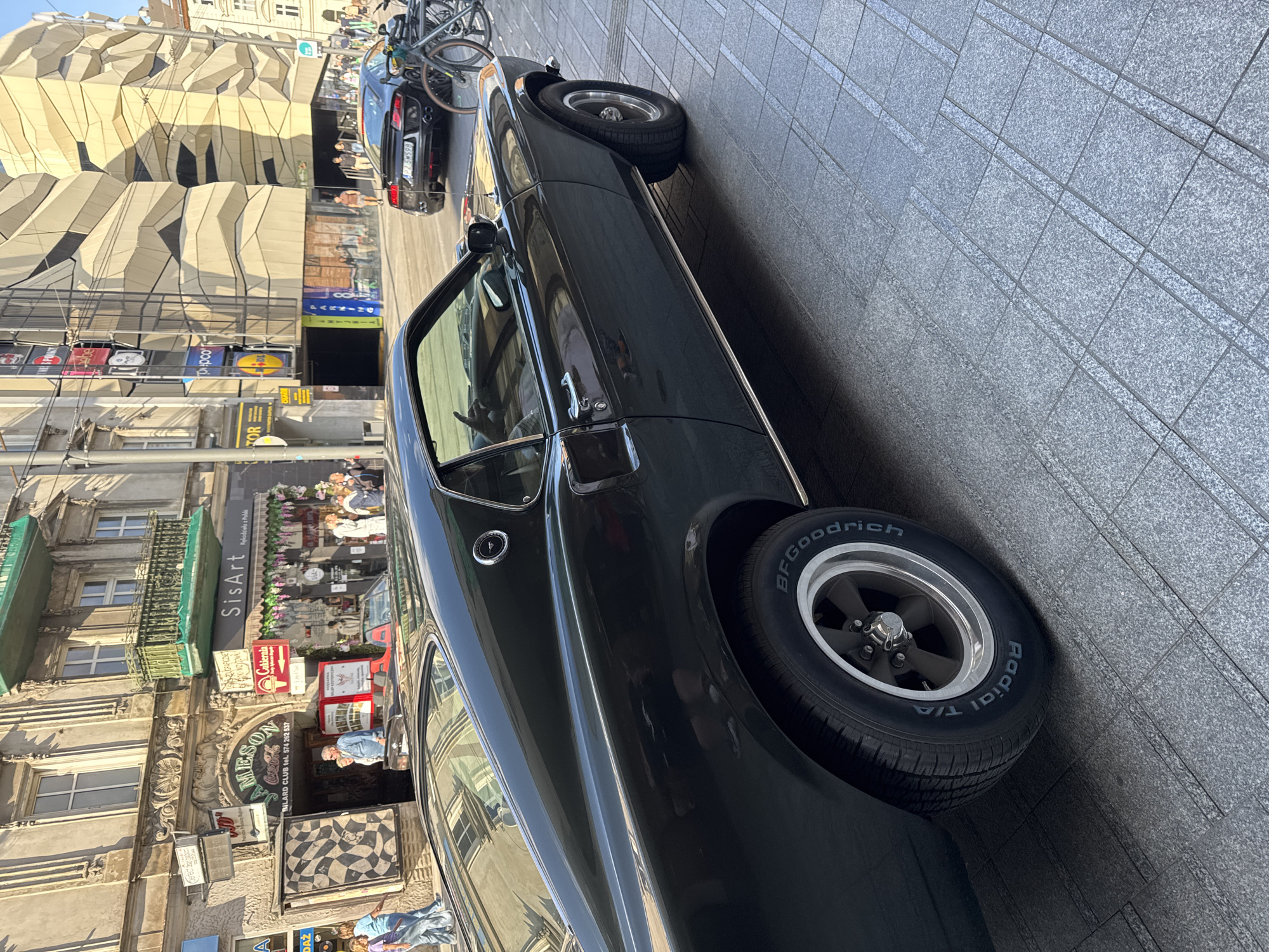Poznań street scene: cars, murals, cafés, and storefronts