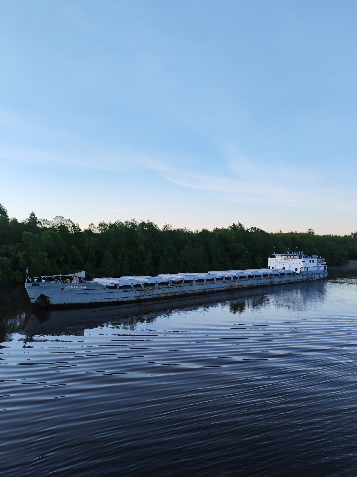 Cargo barges navigate Russian river during twilight hours