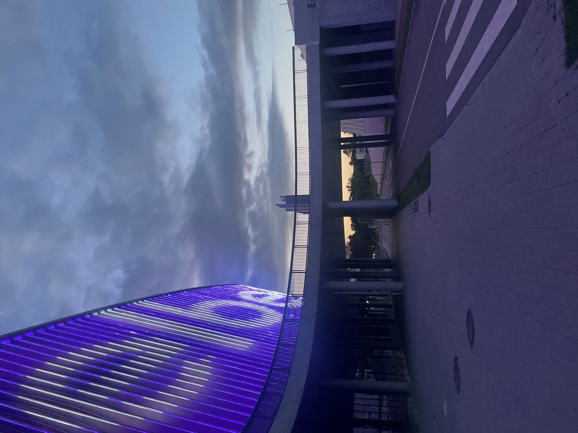 Curved stadium glowing at dusk, multiple angles outside