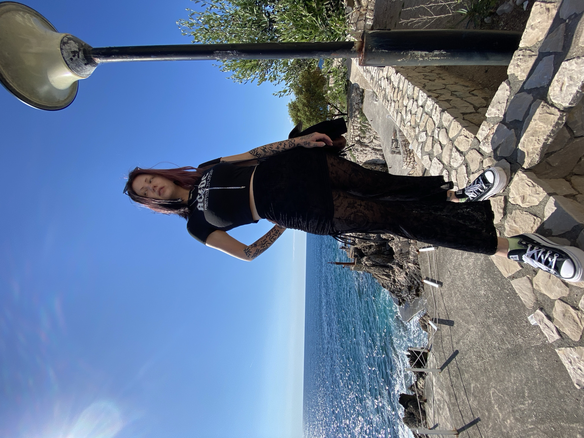 Woman poses on coastal stones in Kunje, Montenegro