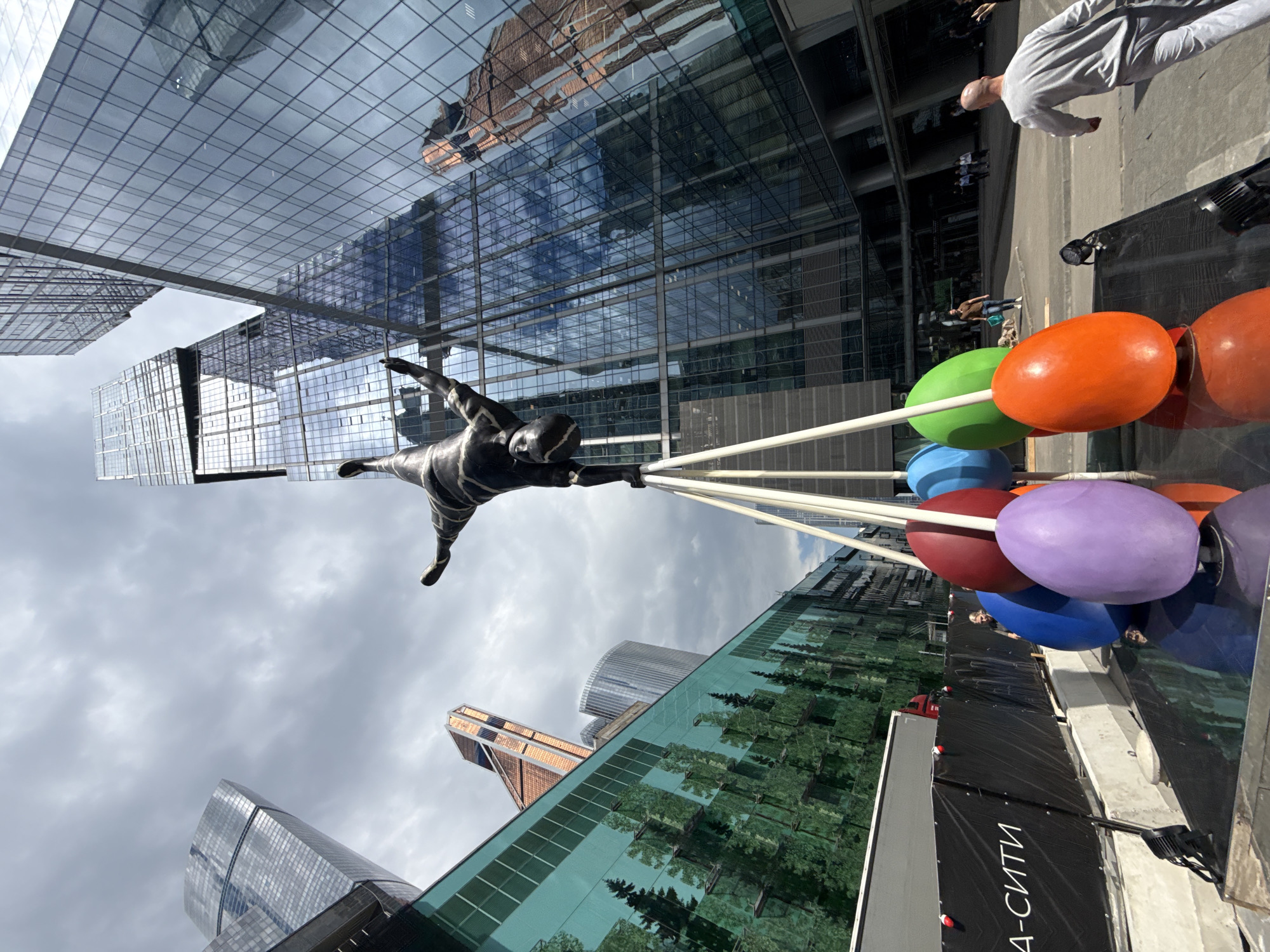 Handstand sculpture stands before Moscow's modern skyscrapers