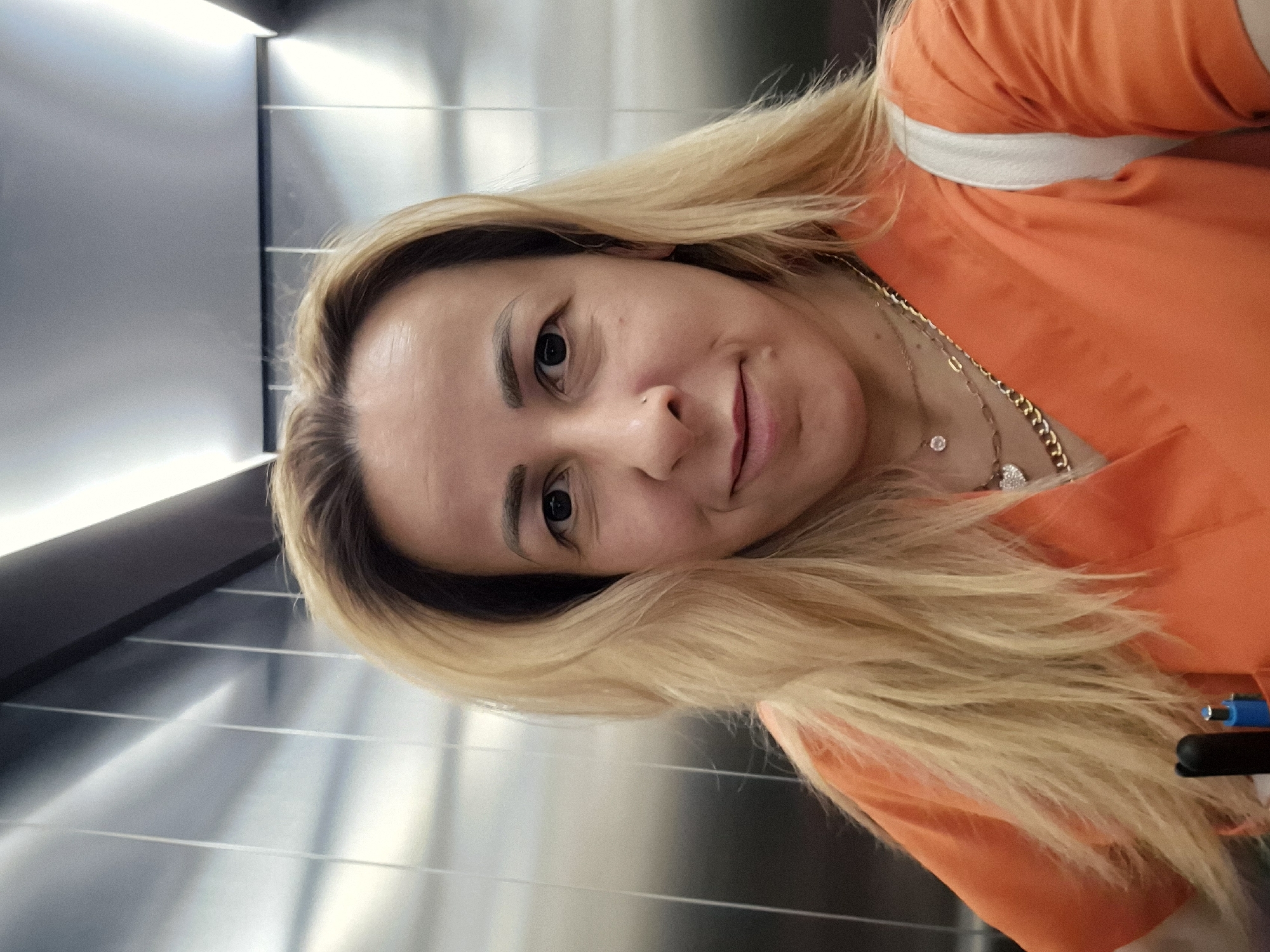 Woman takes selfies near outdoor patio during evening hours
