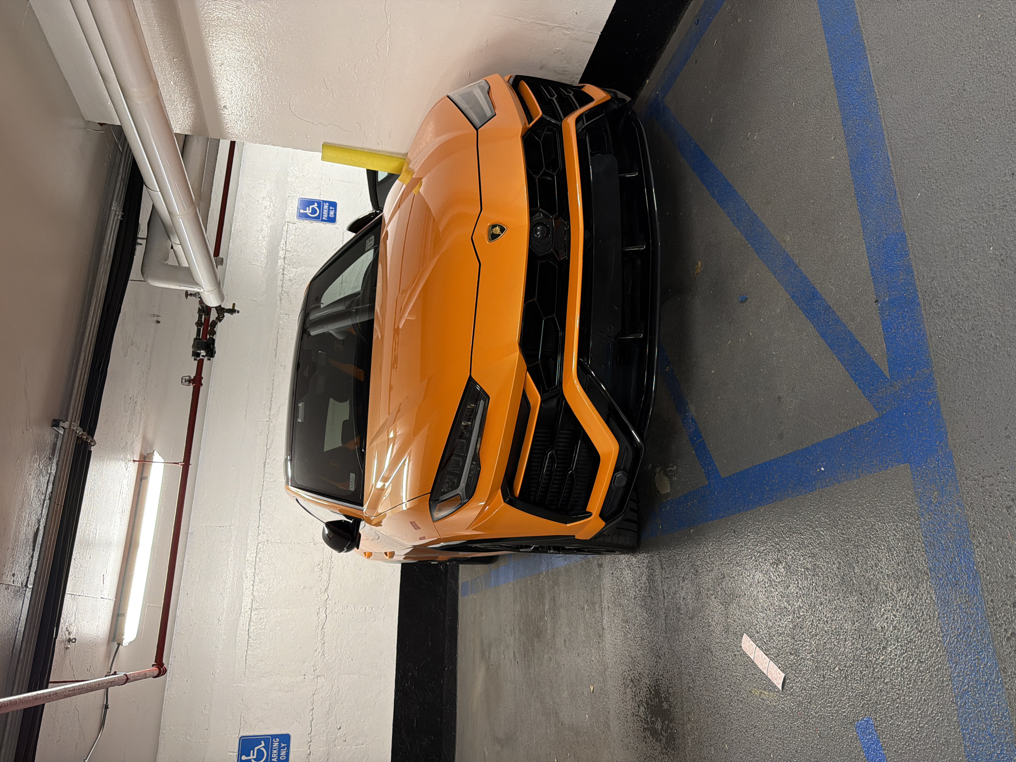 Orange Lamborghini in handicapped spot, Midtown NYC garage