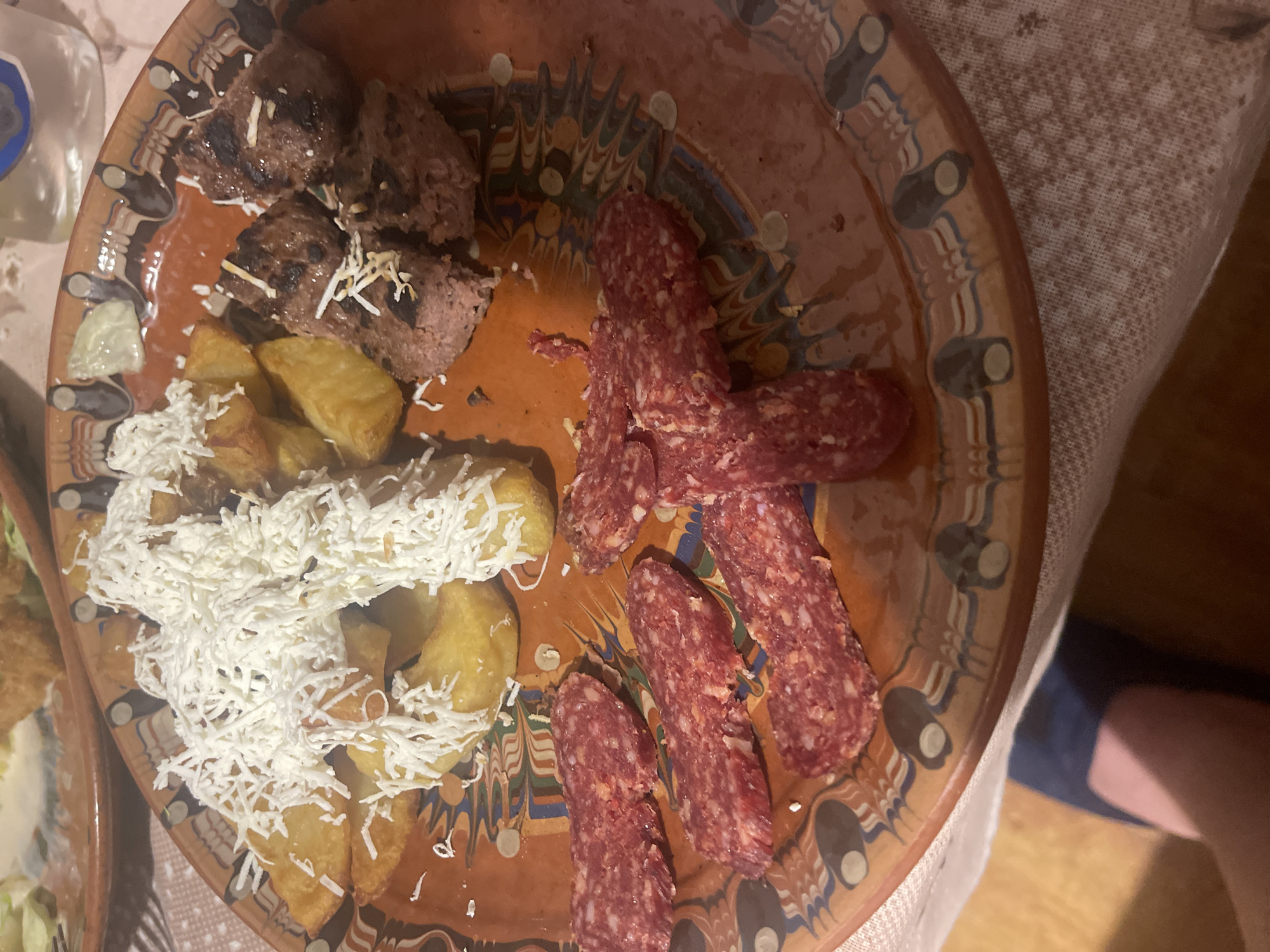 Evening dinner documented with traditional ceramics, cured meats, vodka