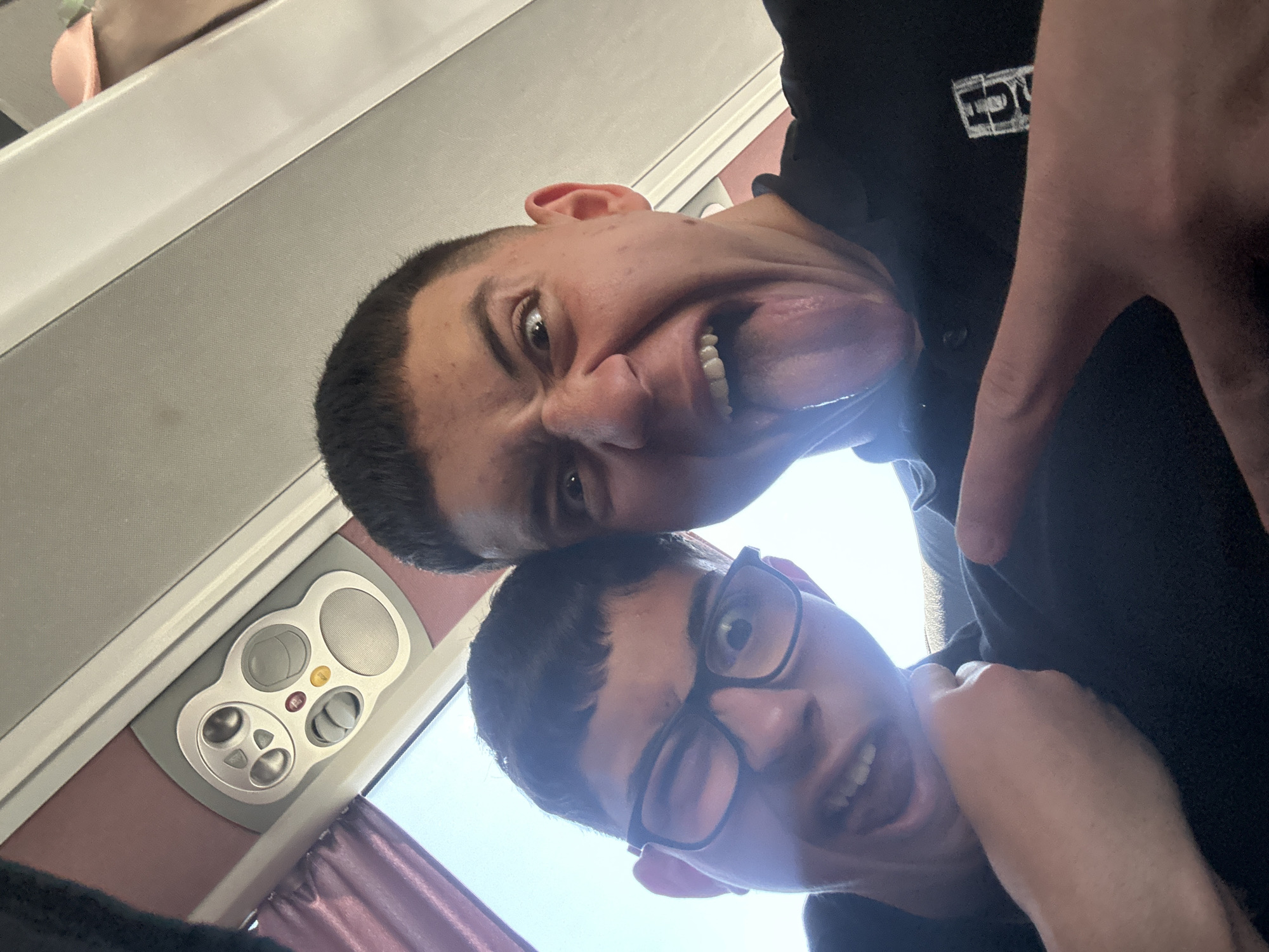 Two men take playful selfie on transport in Greece