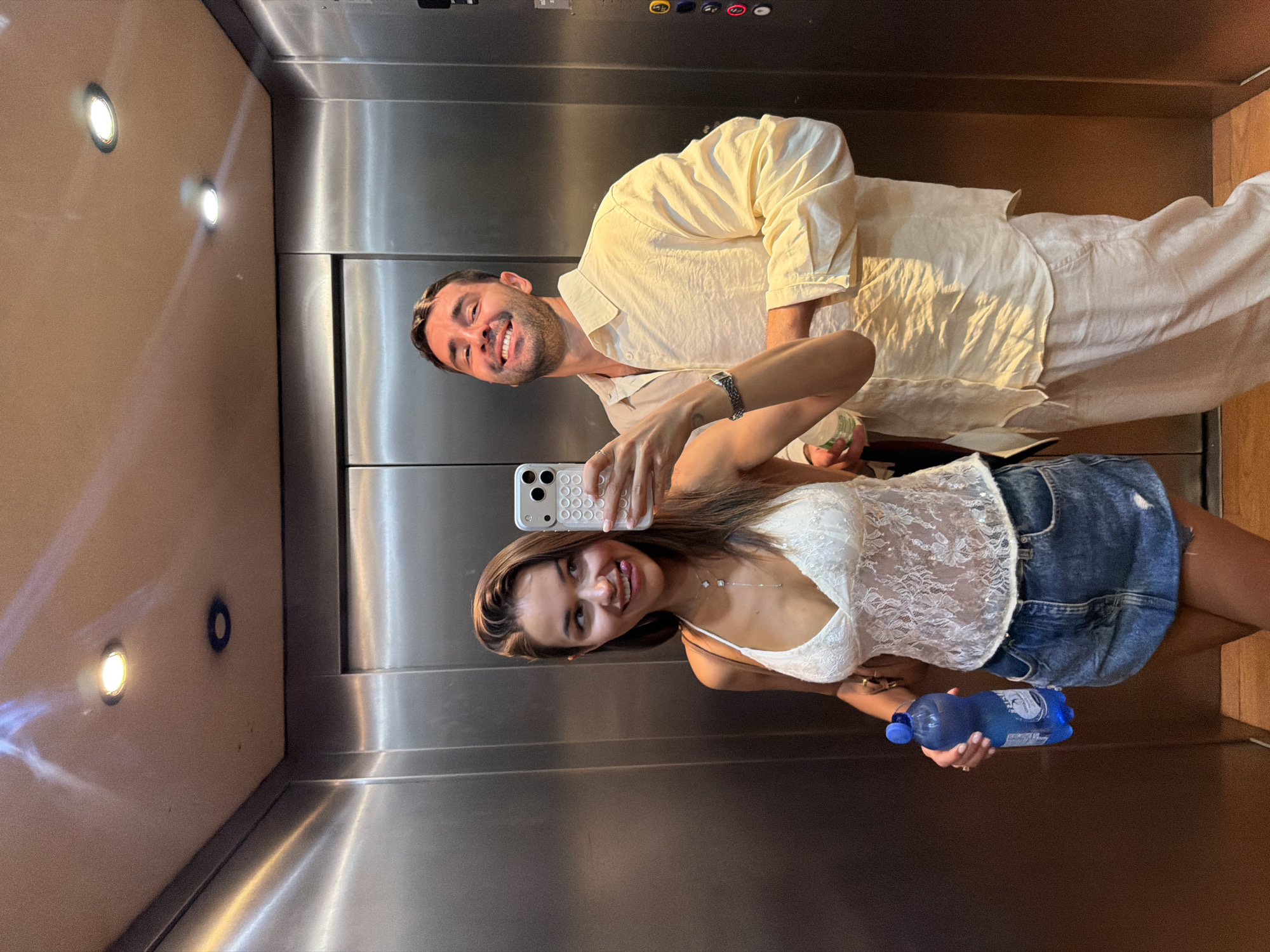 Elevator selfie moment in Milan with a blue water bottle in hand