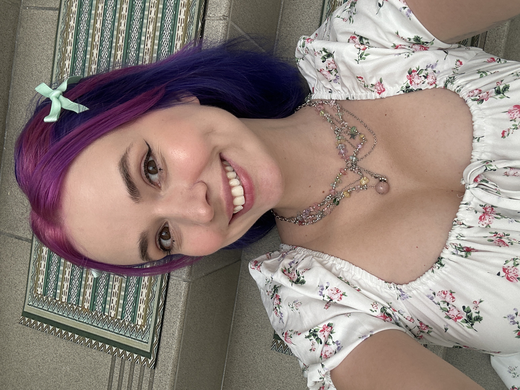Purple-haired woman poses playfully on Zagreb staircase