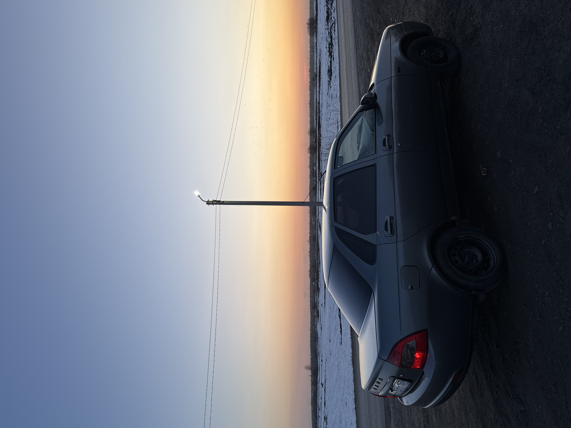 Grey Lada parked roadside during sunset in Кондратово, Russia