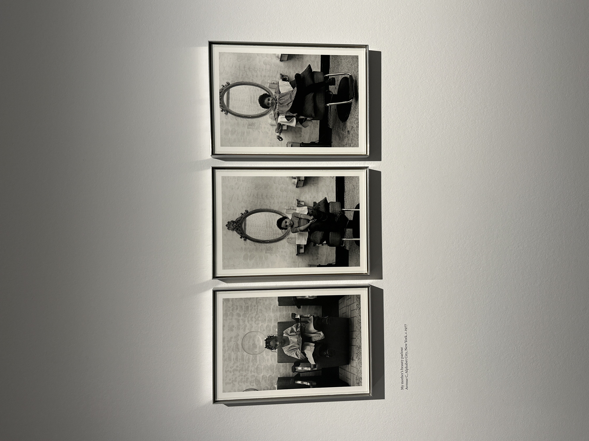 Three framed photos displayed vertically in London gallery space