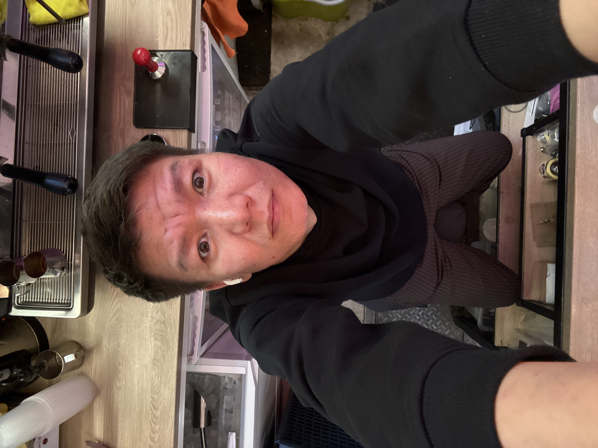 High-angle selfie in a café with espresso machine backdrop