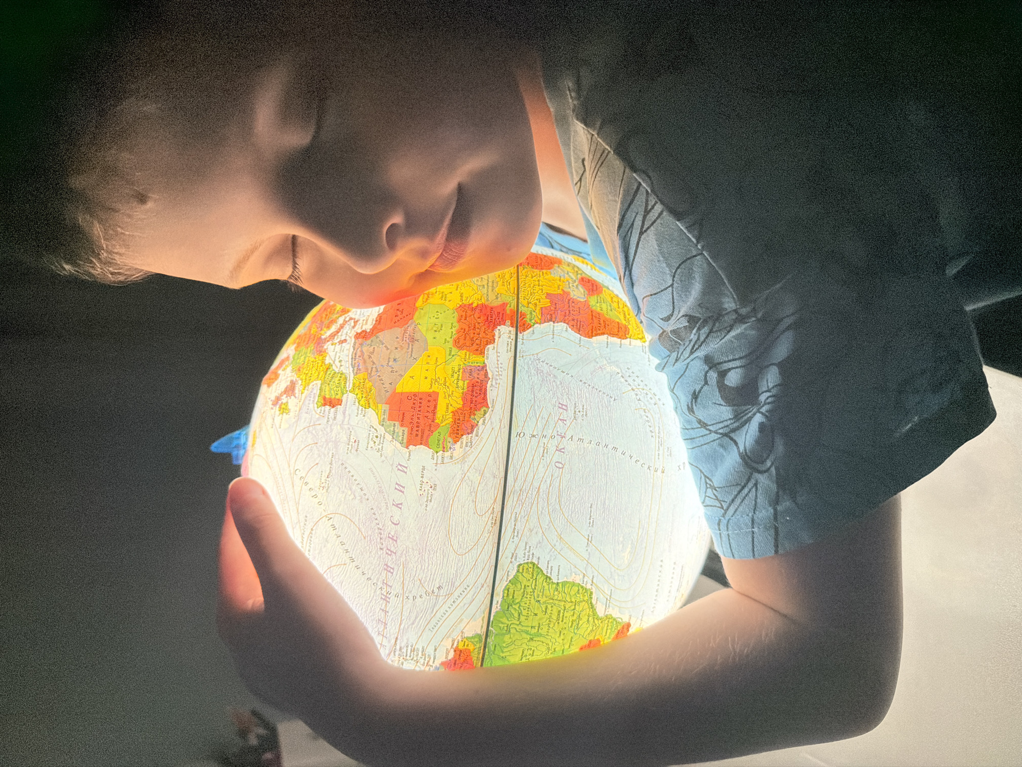 Child explores world globe, reads scary stories in Votkinsk bedroom