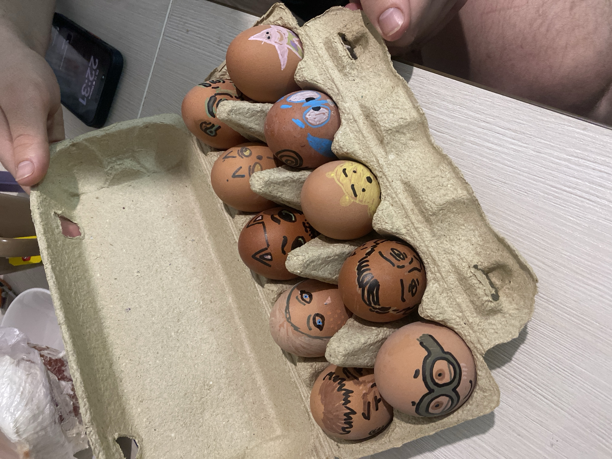 Person decorates brown eggs with cartoon faces in Izhevsk