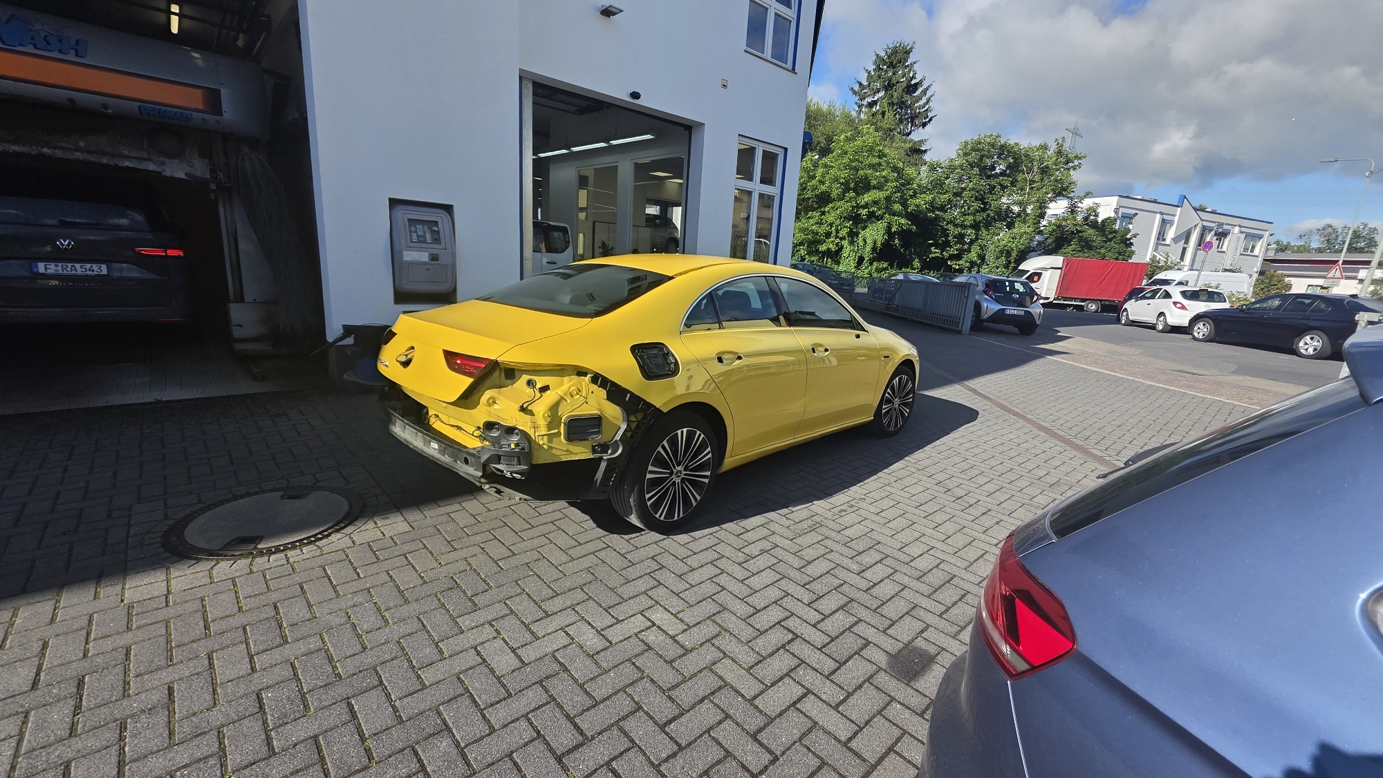 Damaged Yellow Mercedes Observed at Commercial Building