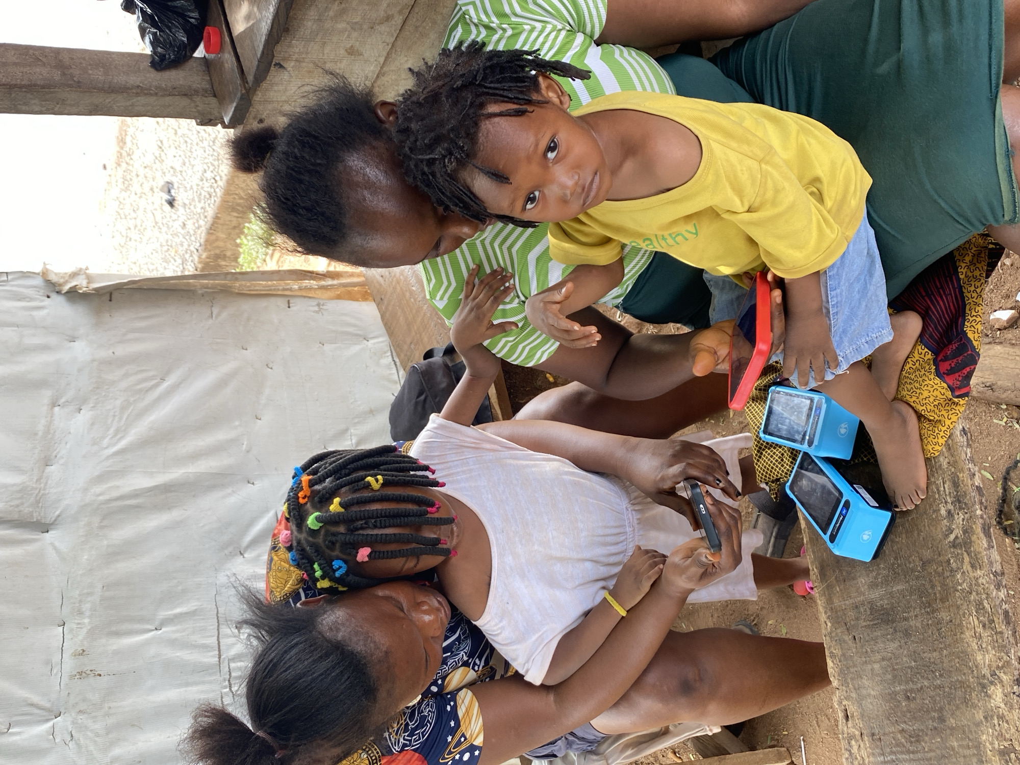 Two women, two children gather on bench in Adankolo