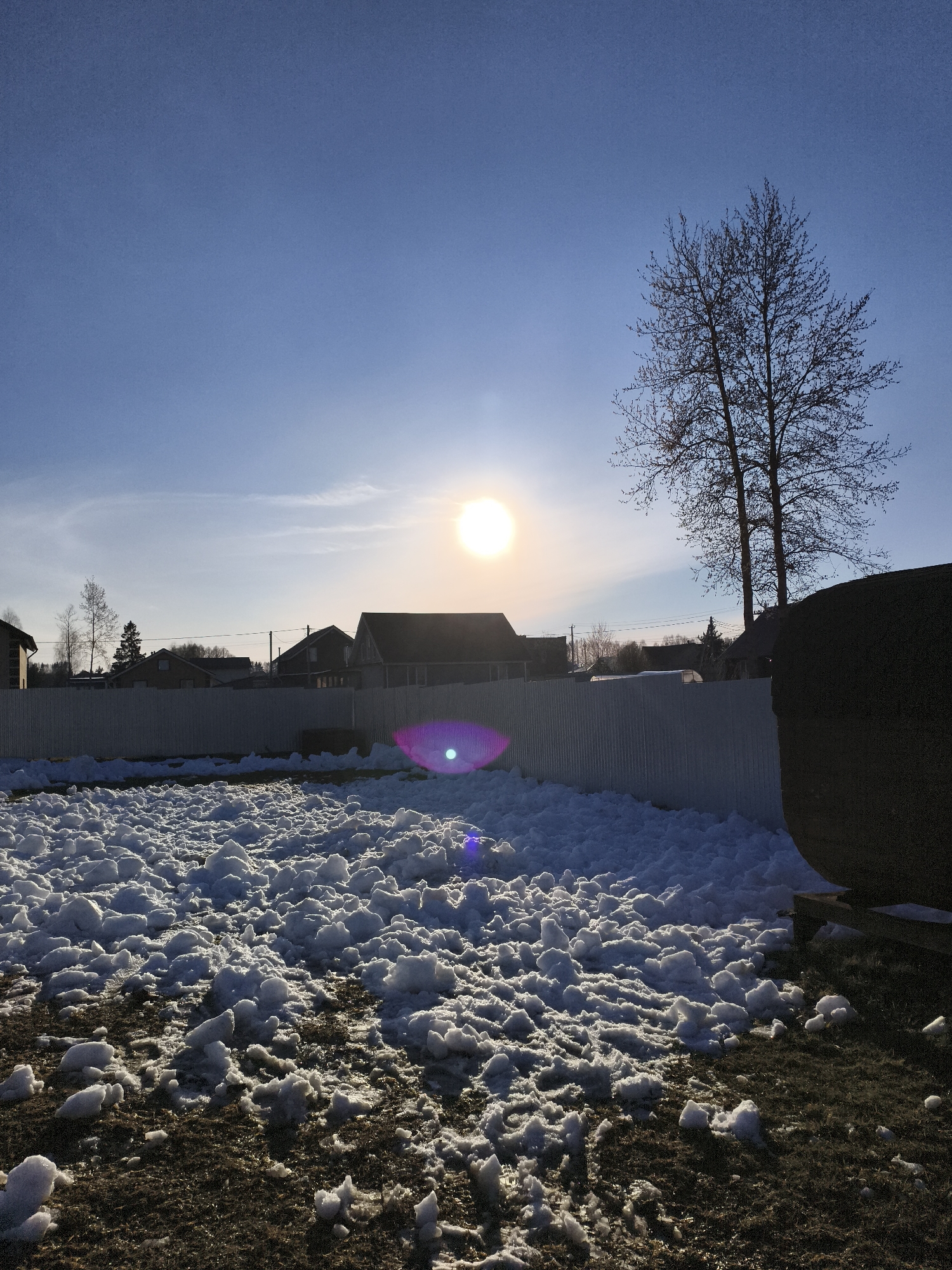 Snow-covered backyard observed under clear skies in rural Russia