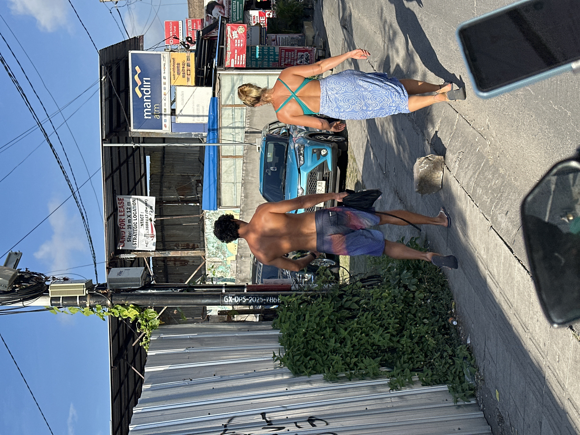 Scooters, surfers, and foot traffic on a North Kuta street