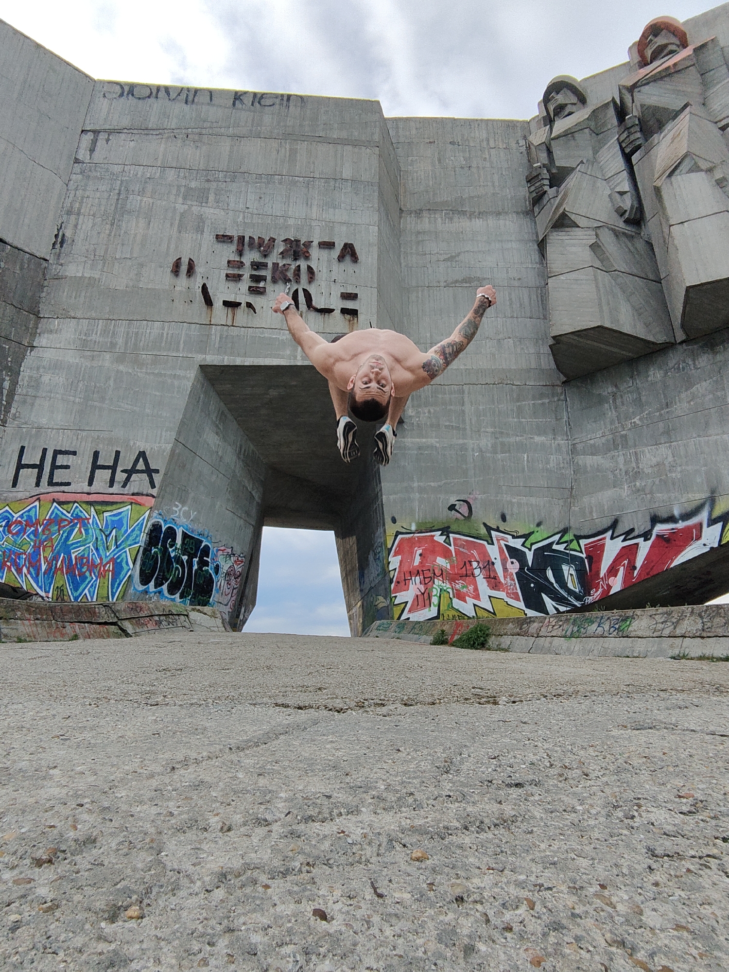 Man performs acrobatics at graffitied Bulgarian Soviet monuments