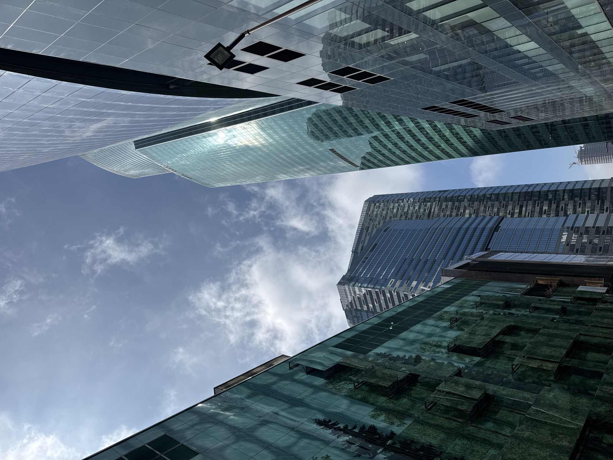 Witness captures upward view of clustered glass buildings