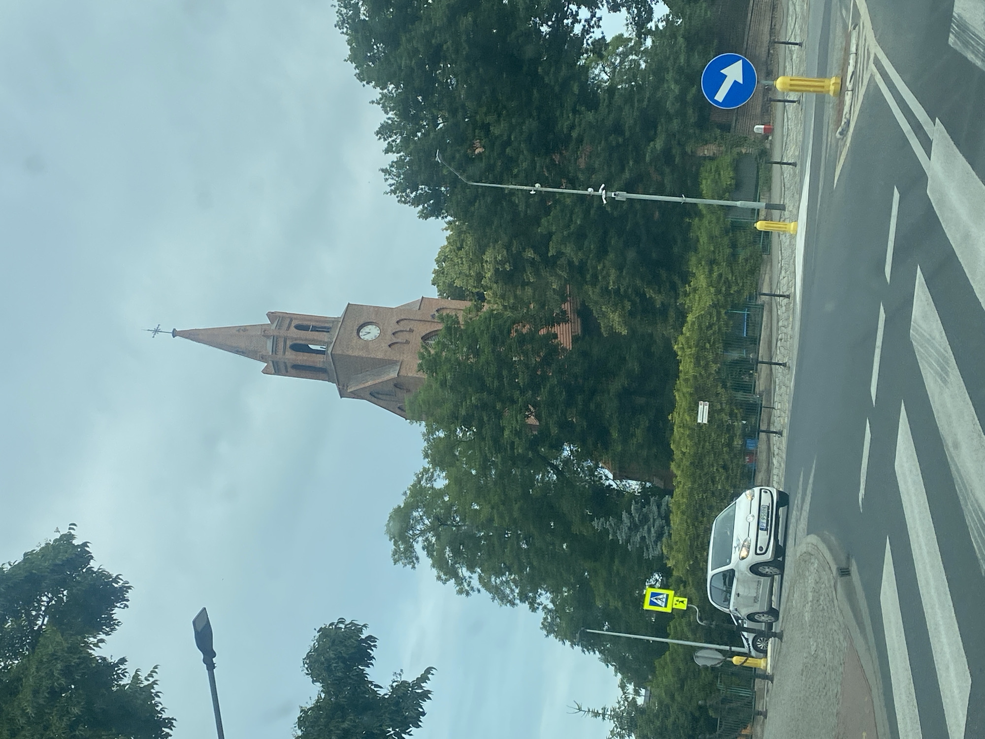 Red brick church tower at a Miłosław crosswalk