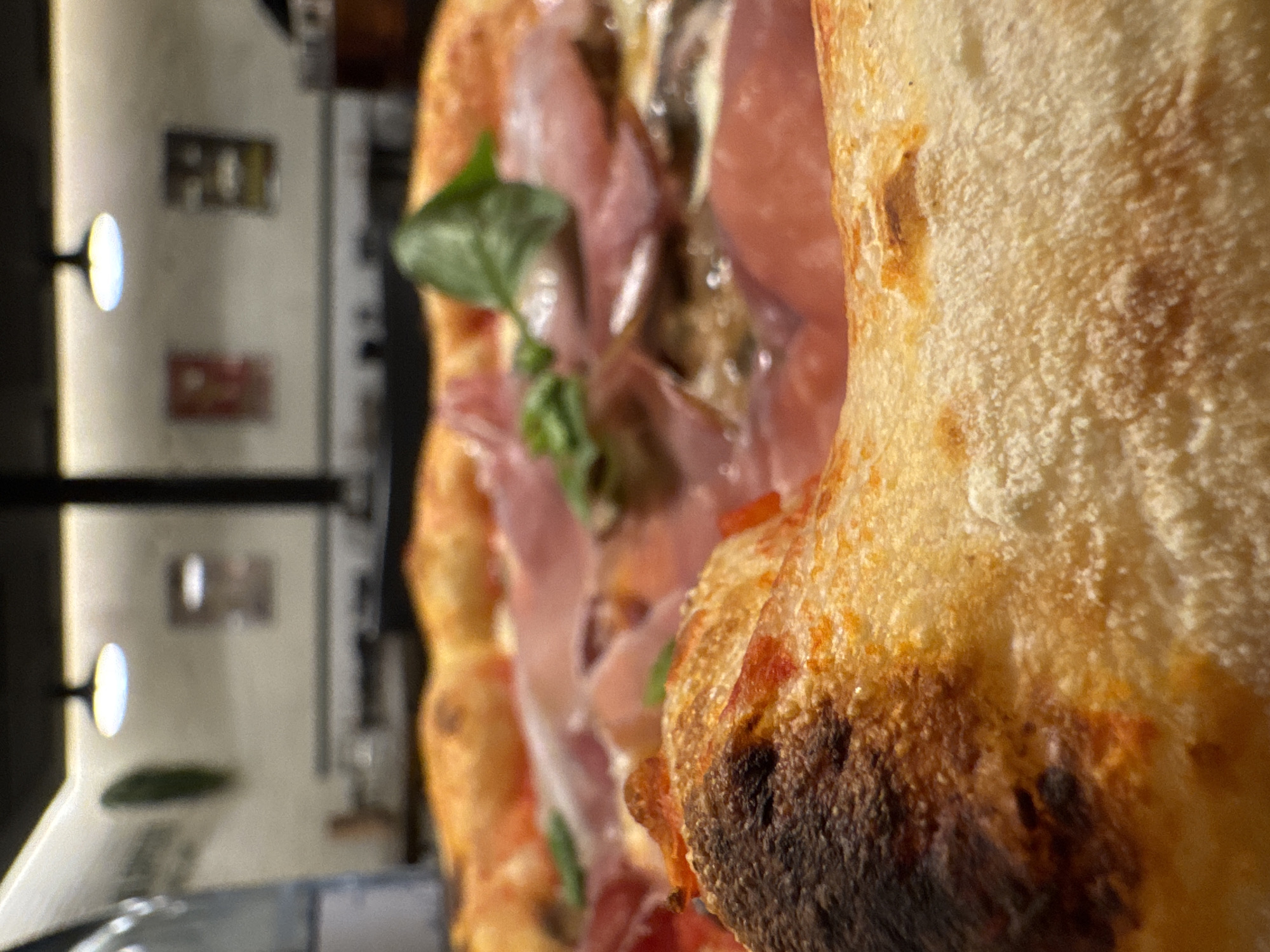 Pizza photograph captured in Barcelona showing prosciutto basil toppings