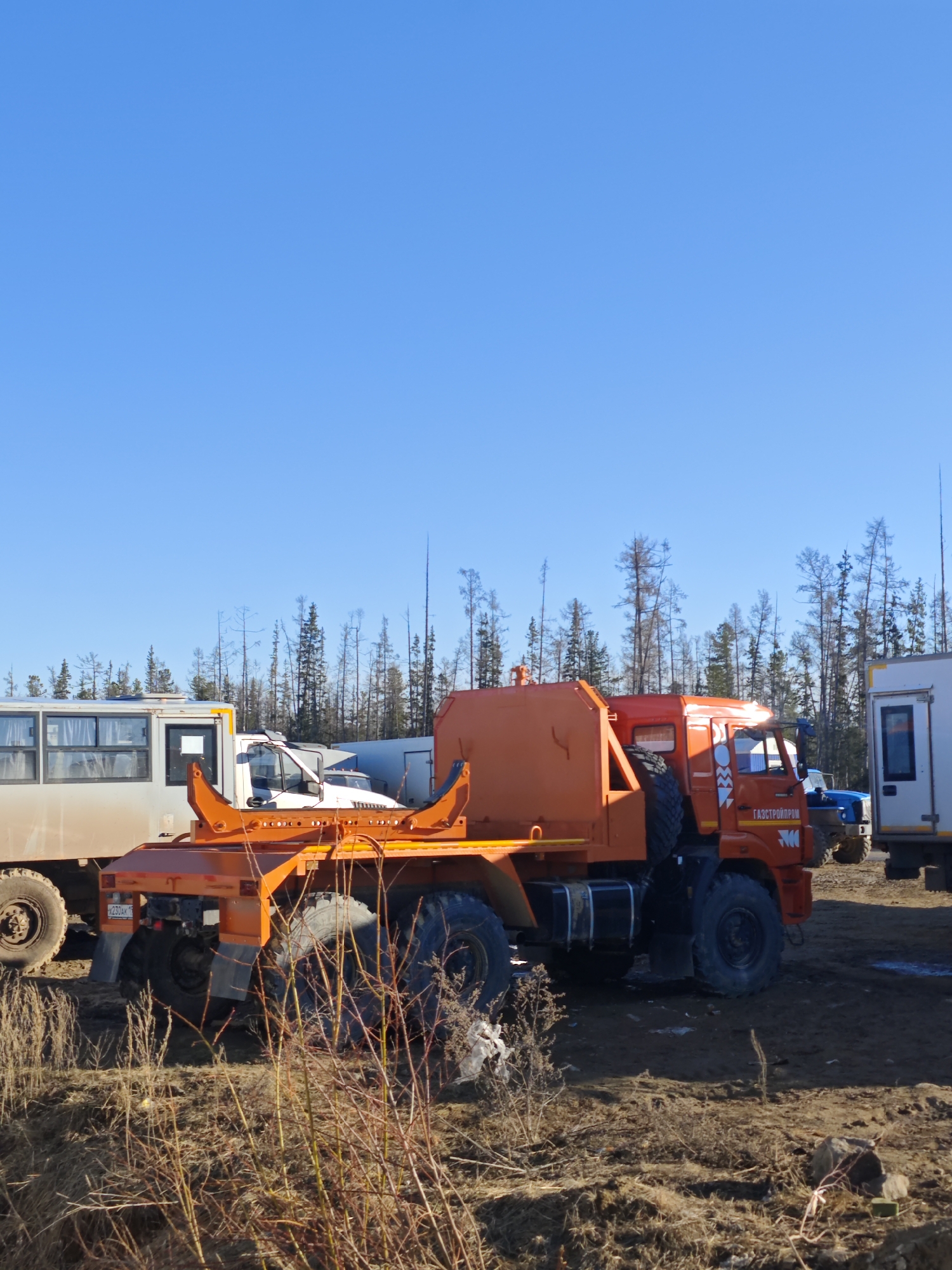 Construction site with orange truck, gravel piles observed in Russia