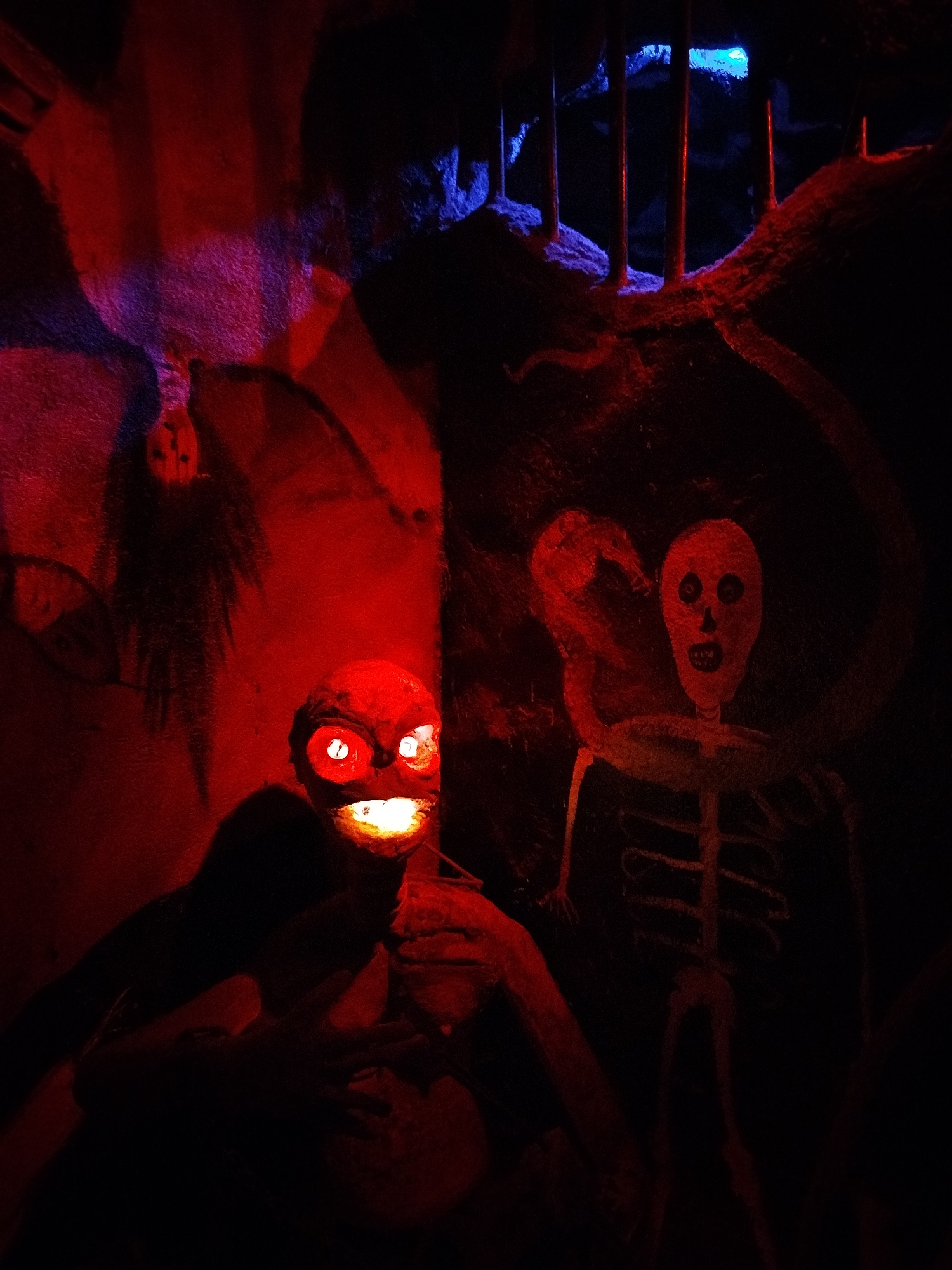 Horror attraction display captured with dramatic lighting and caged figures