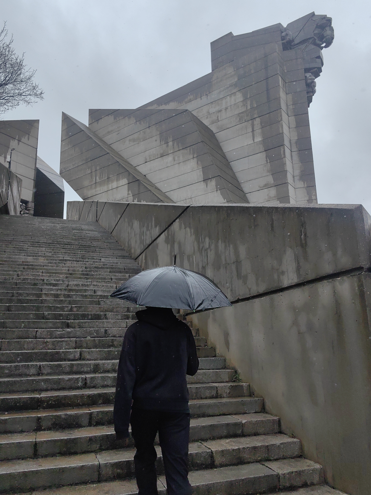 Umbrella-carrying visitor climbs stairs to Bulgarian historical monument