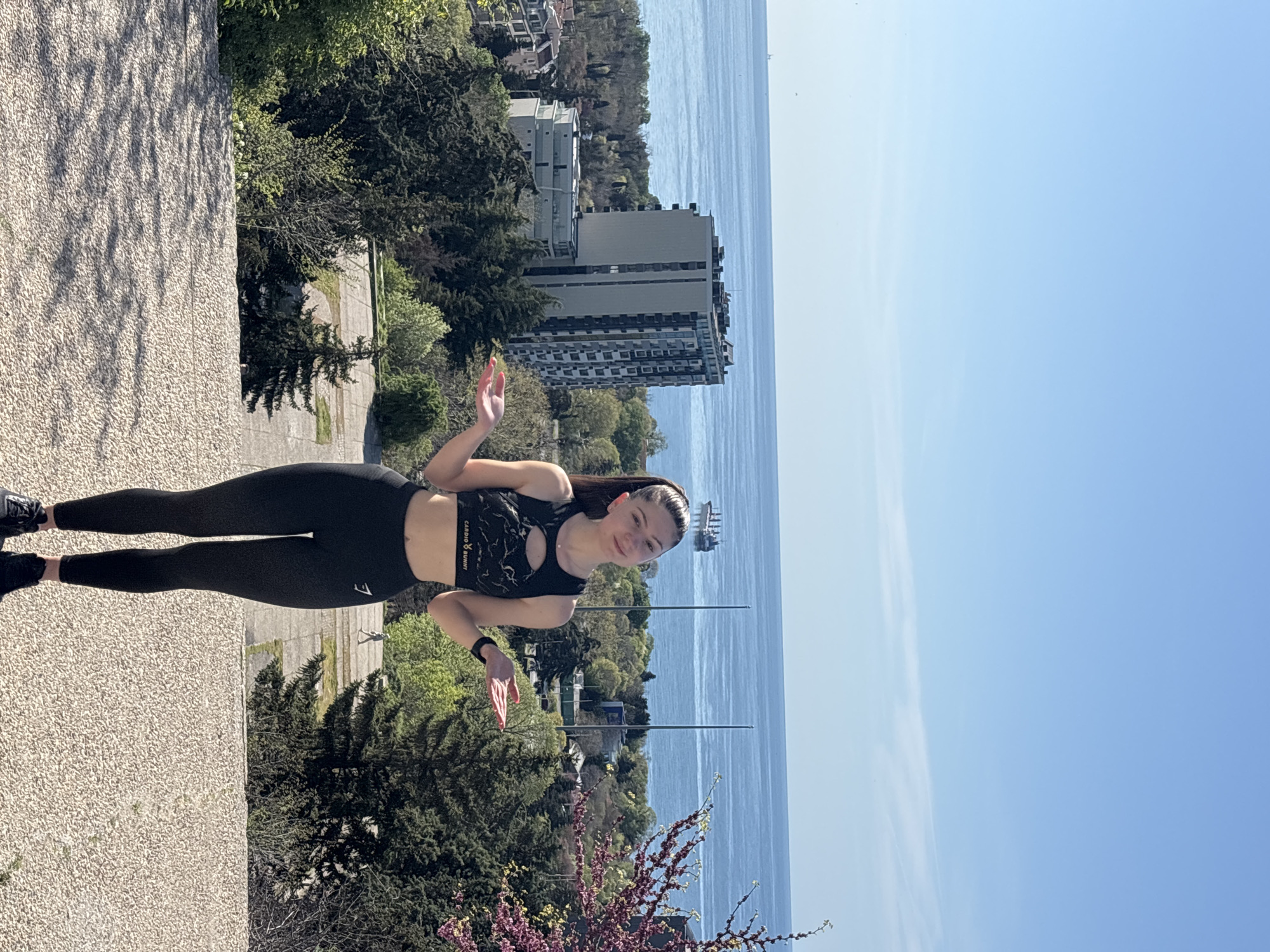 Woman exercises at coastal viewpoint with colorful manicure