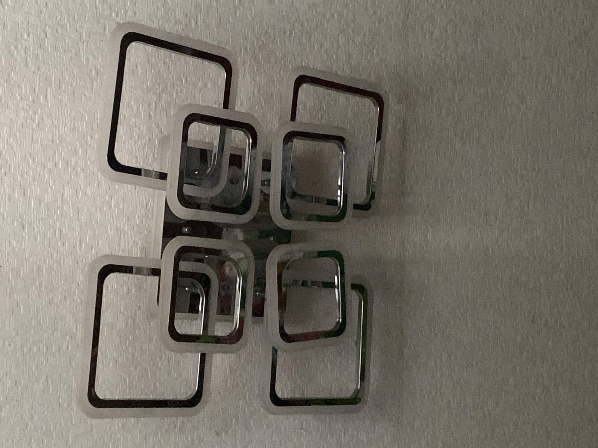 Interior wall details: chrome light fixture and mounted TV