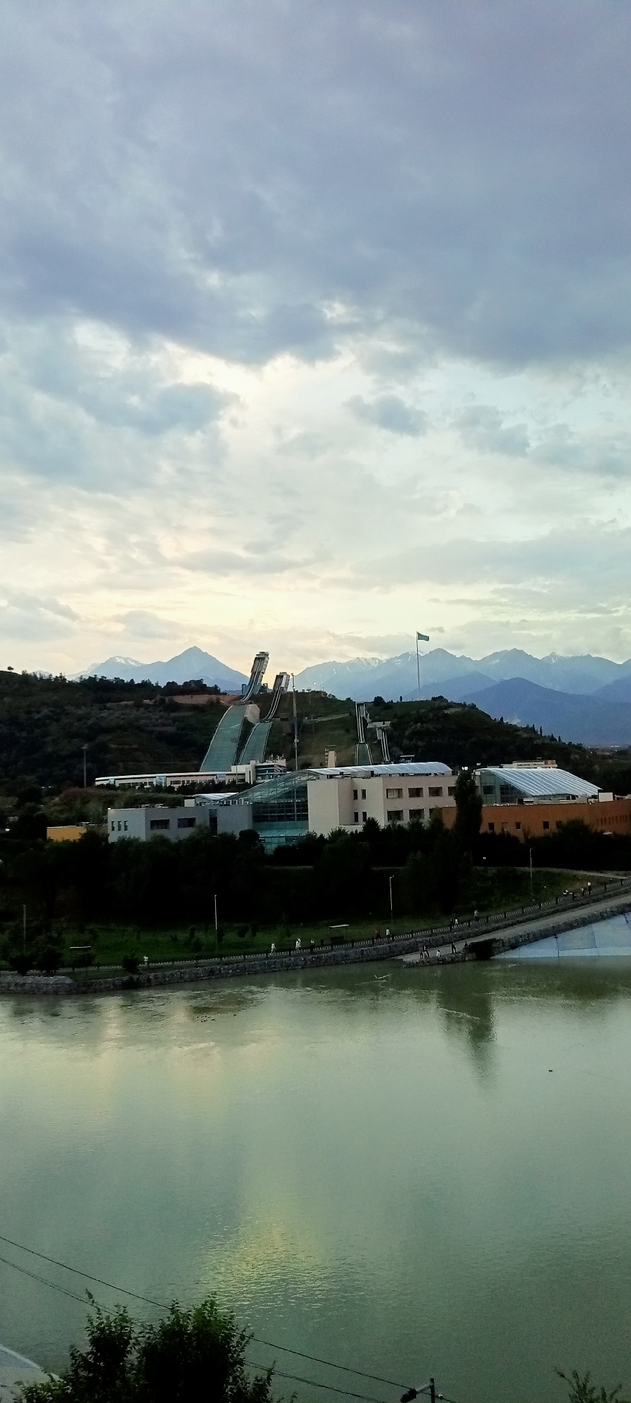 Almaty skyline and ski jump complex at dusk