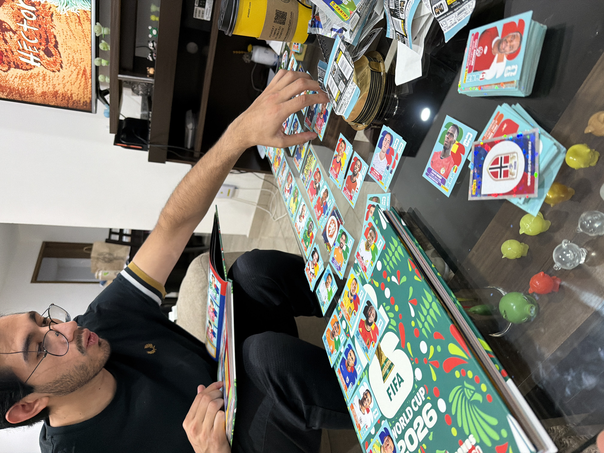 Man reviews FIFA 2026 sticker album at home