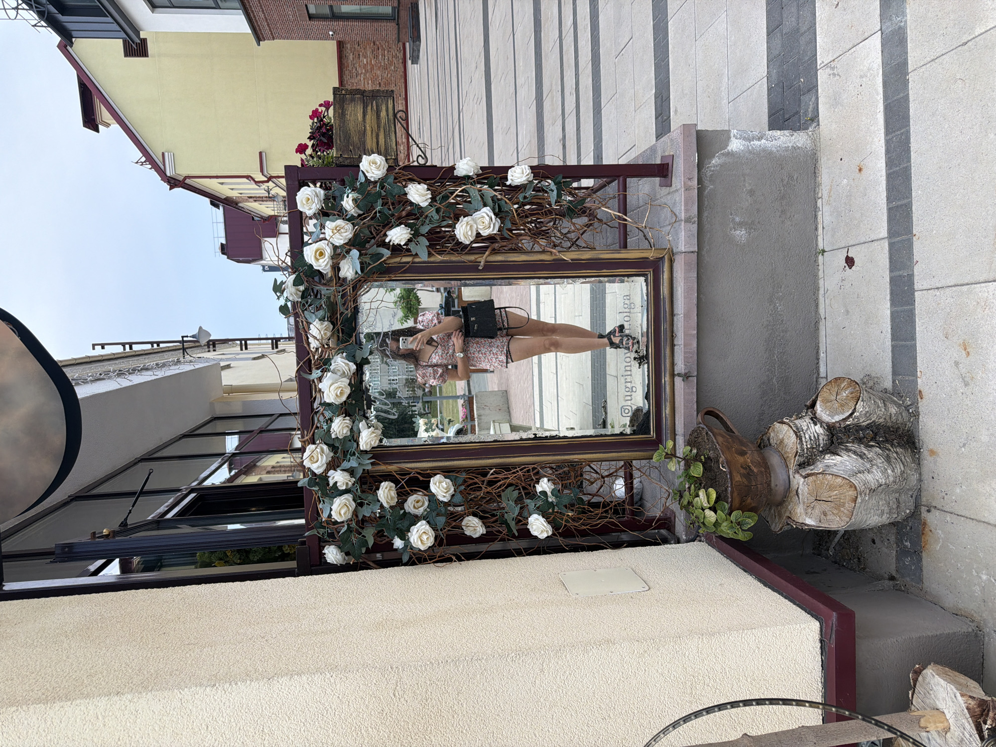 Ornate outdoor piano and mirror setup styled with artificial florals