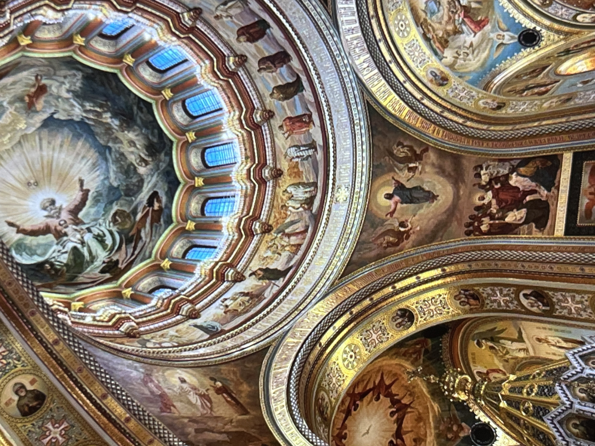 Ornate church interior: frescoed ceiling and glowing candelabra