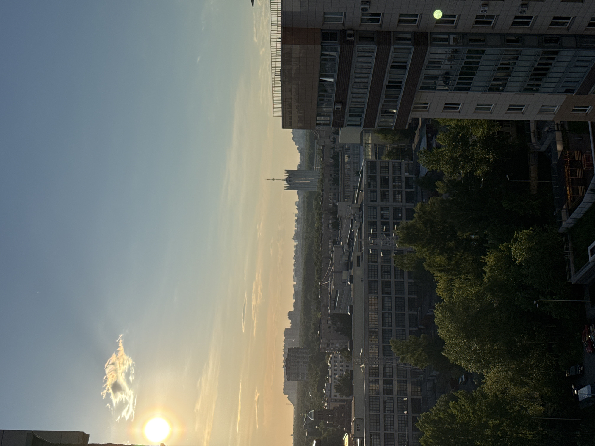 Evening sunset observed over Sinyavino cityscape with cloudy skies