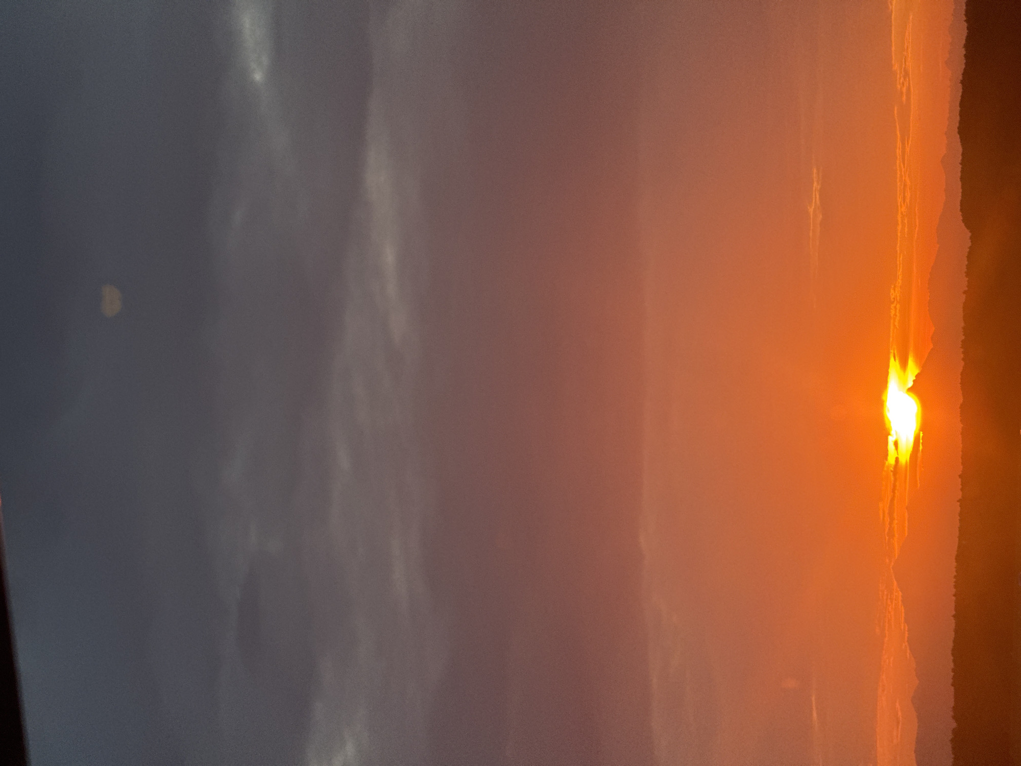Fiery sunset silhouettes the mountains above Ferno, Italy