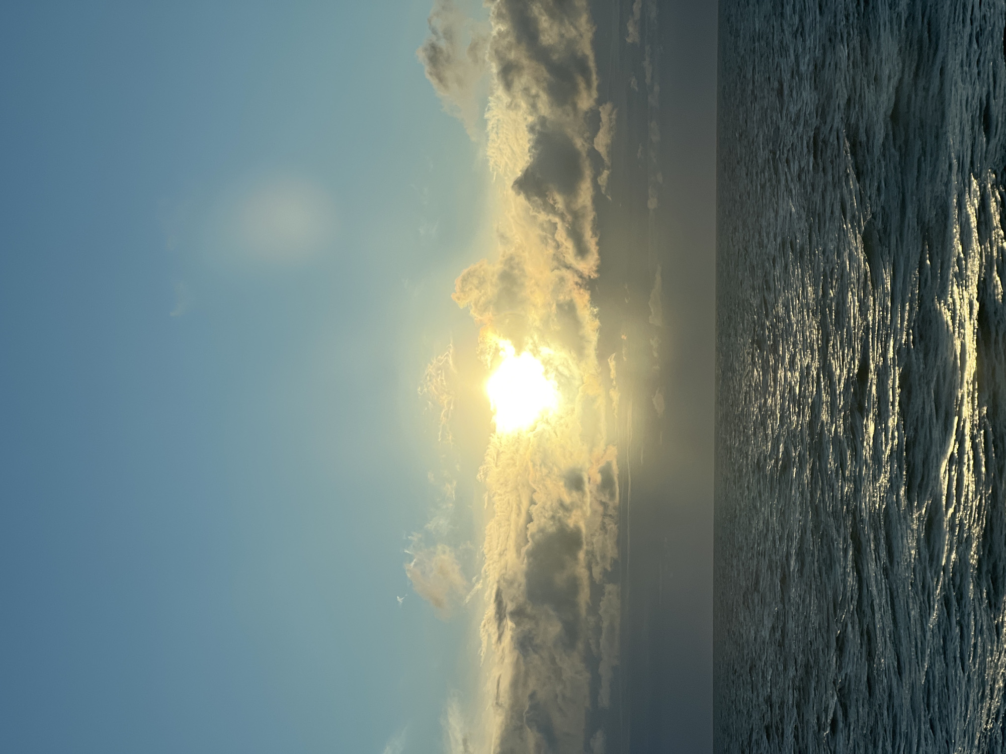 Sun breaks through clouds over a calm Baltic seascape